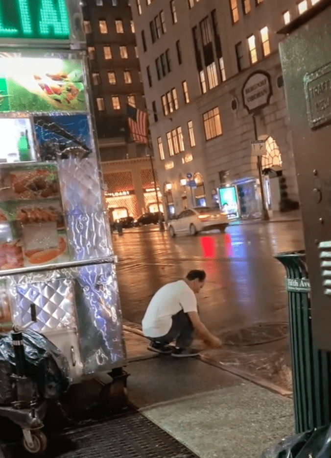 Food cart worker washes his rag in a rainwater puddle right next to his truck | Photo: TikTok/g2bbie