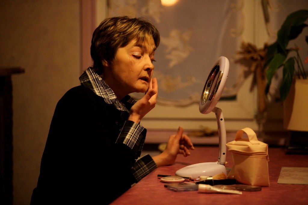 Une femme de 50 ans devant son miroir | source : Getty Images