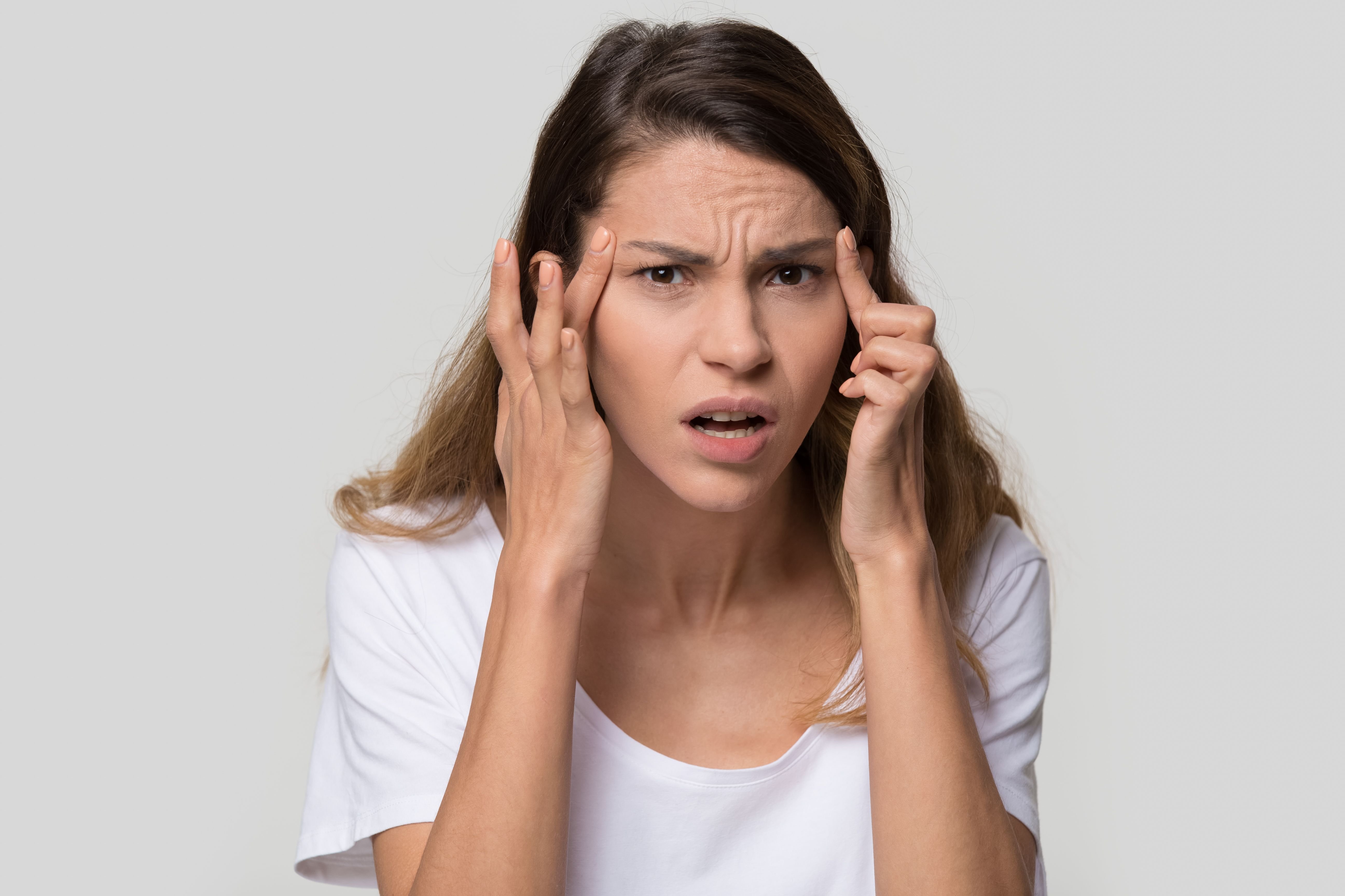 A woman fed up while holding her face. | Source: Shutterstock
