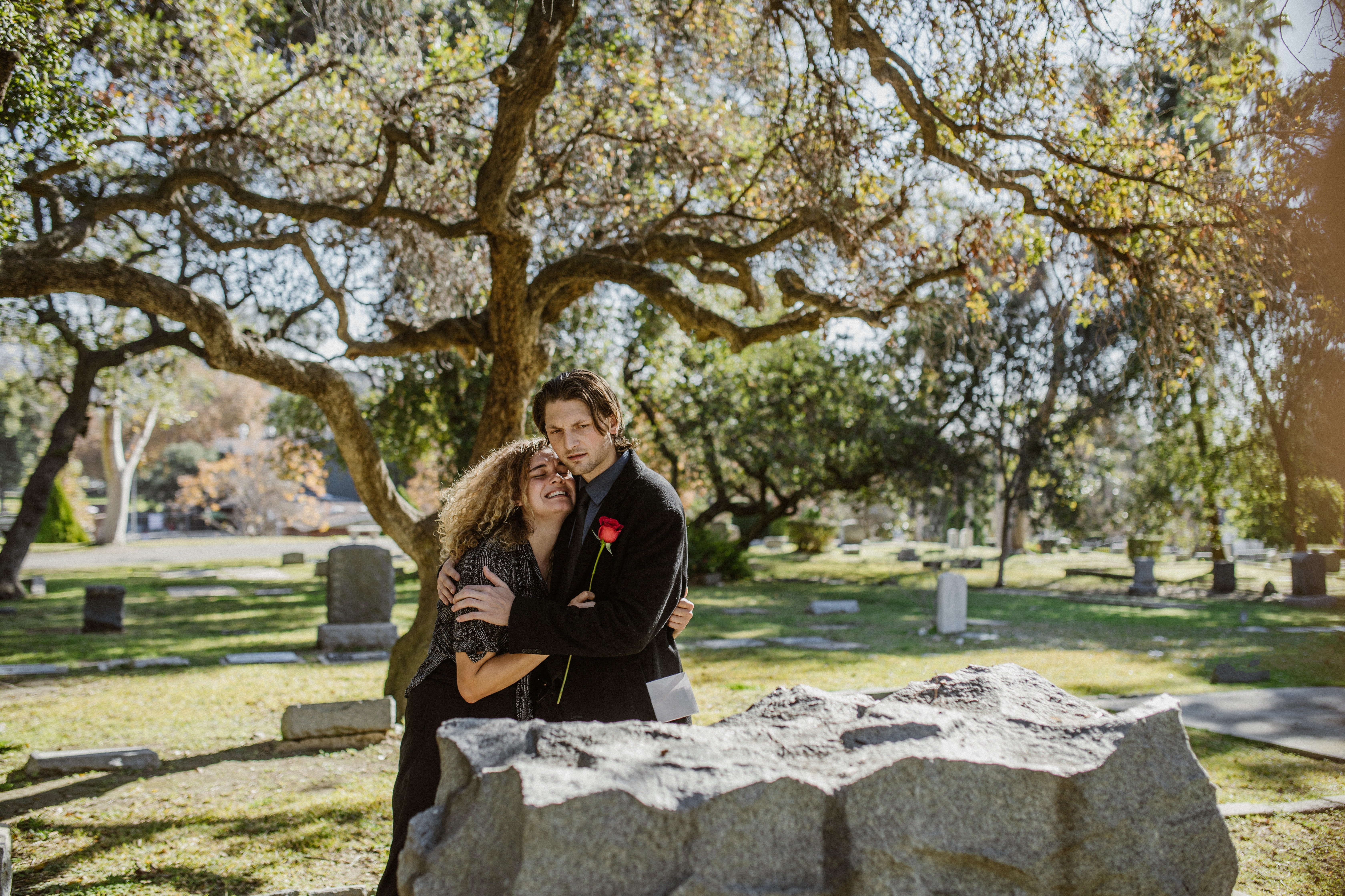 Pareja abrazada en un cementerio. | Foto: Pexels