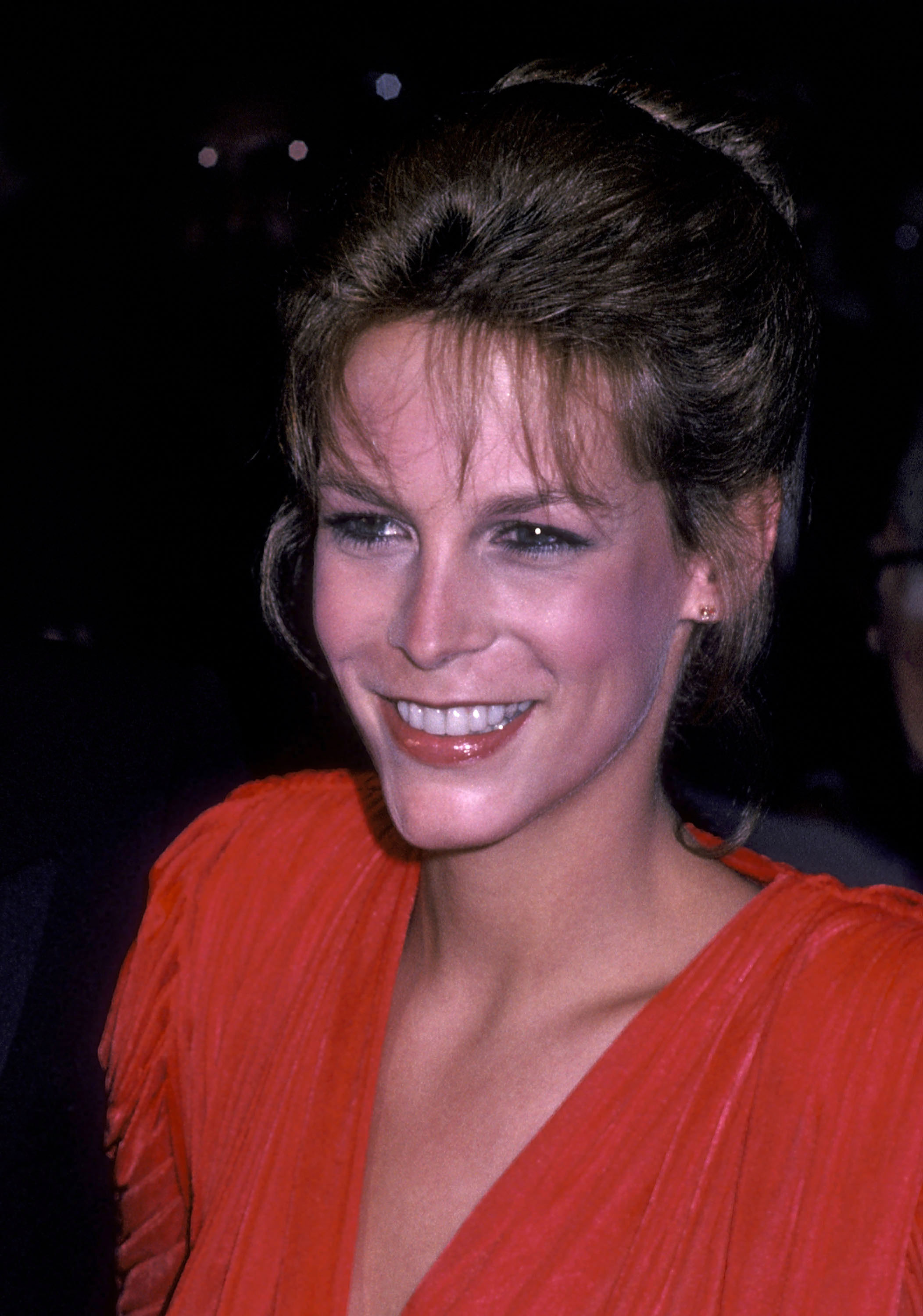 Jamie Lee Curtis glows in a pleated red gown at the premiere of “Rich and Famous,” turning heads at the Ziegfeld Theatre during a glamorous New York City night.