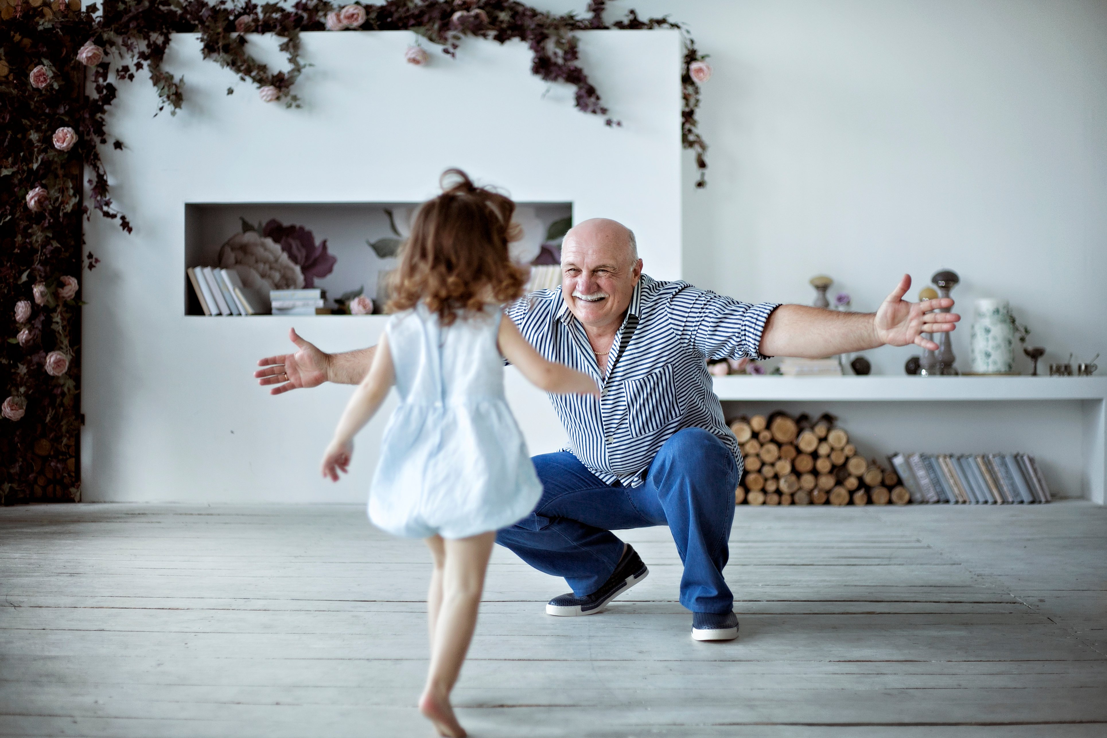 A little girl runs toward her grandfather | Source: Shutterstock