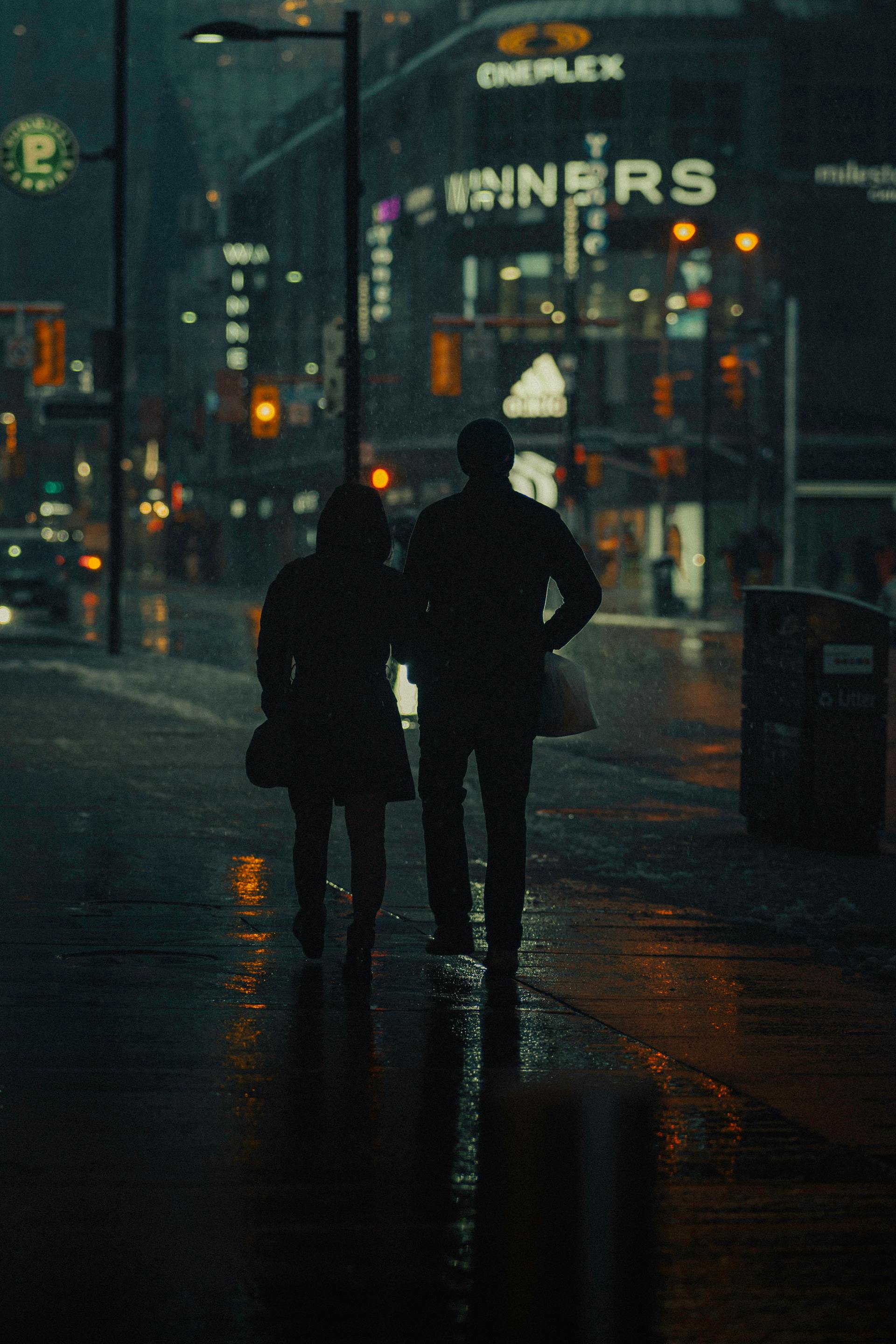 Silhouette of a couple walking down the street at night | Source: Pexels