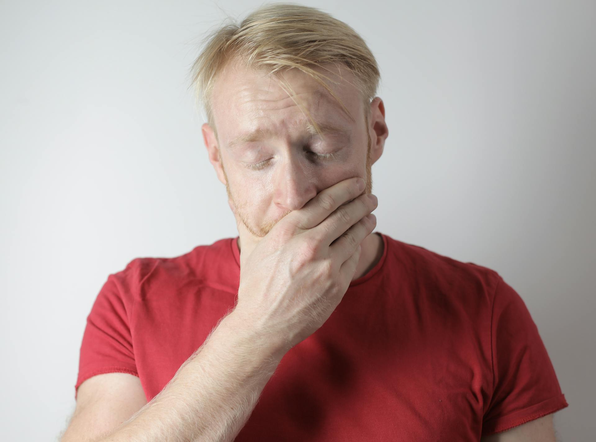 An anxious man covering his mouth | Source: Pexels