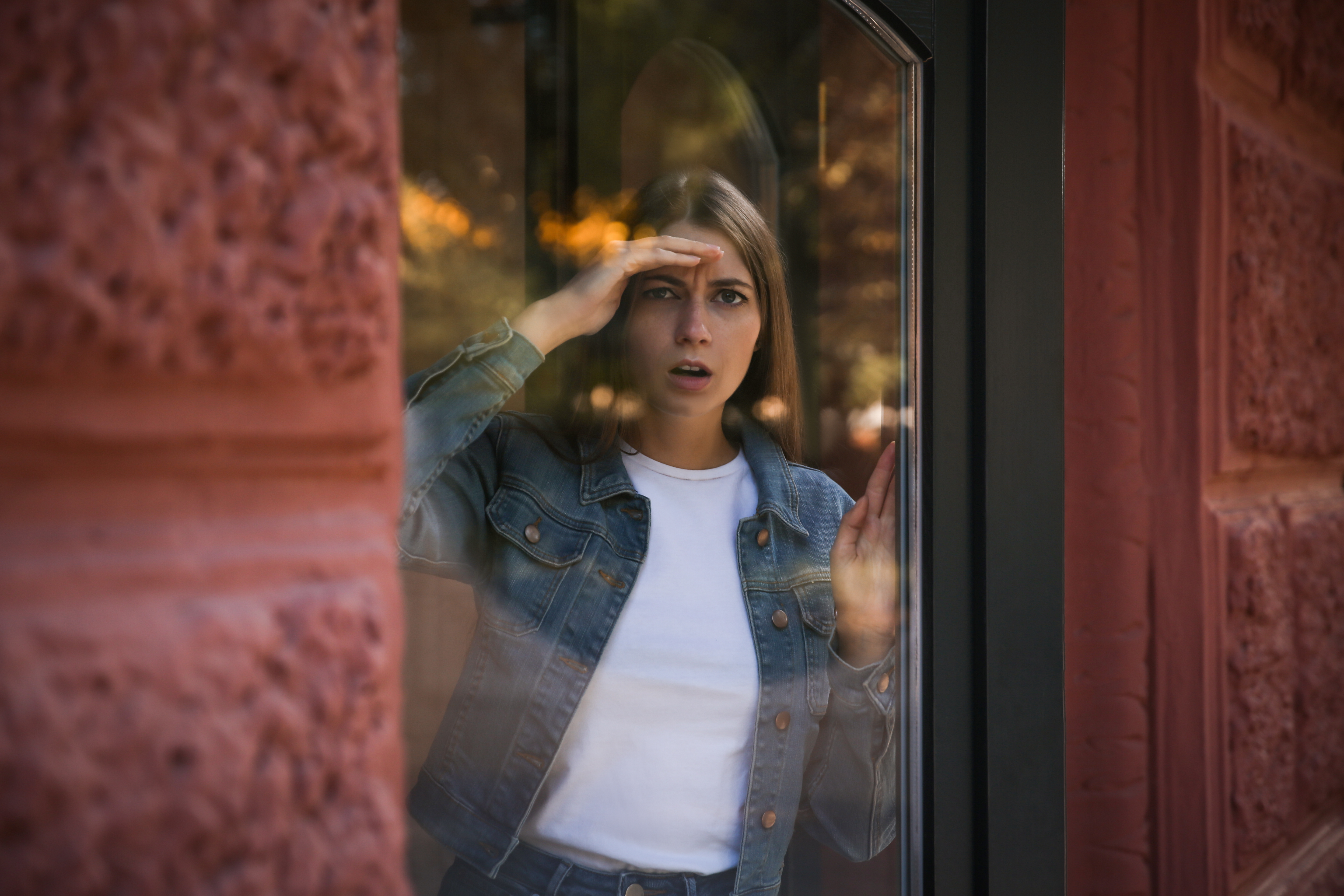 A confused woman looking outside a window | Source: Shutterstock