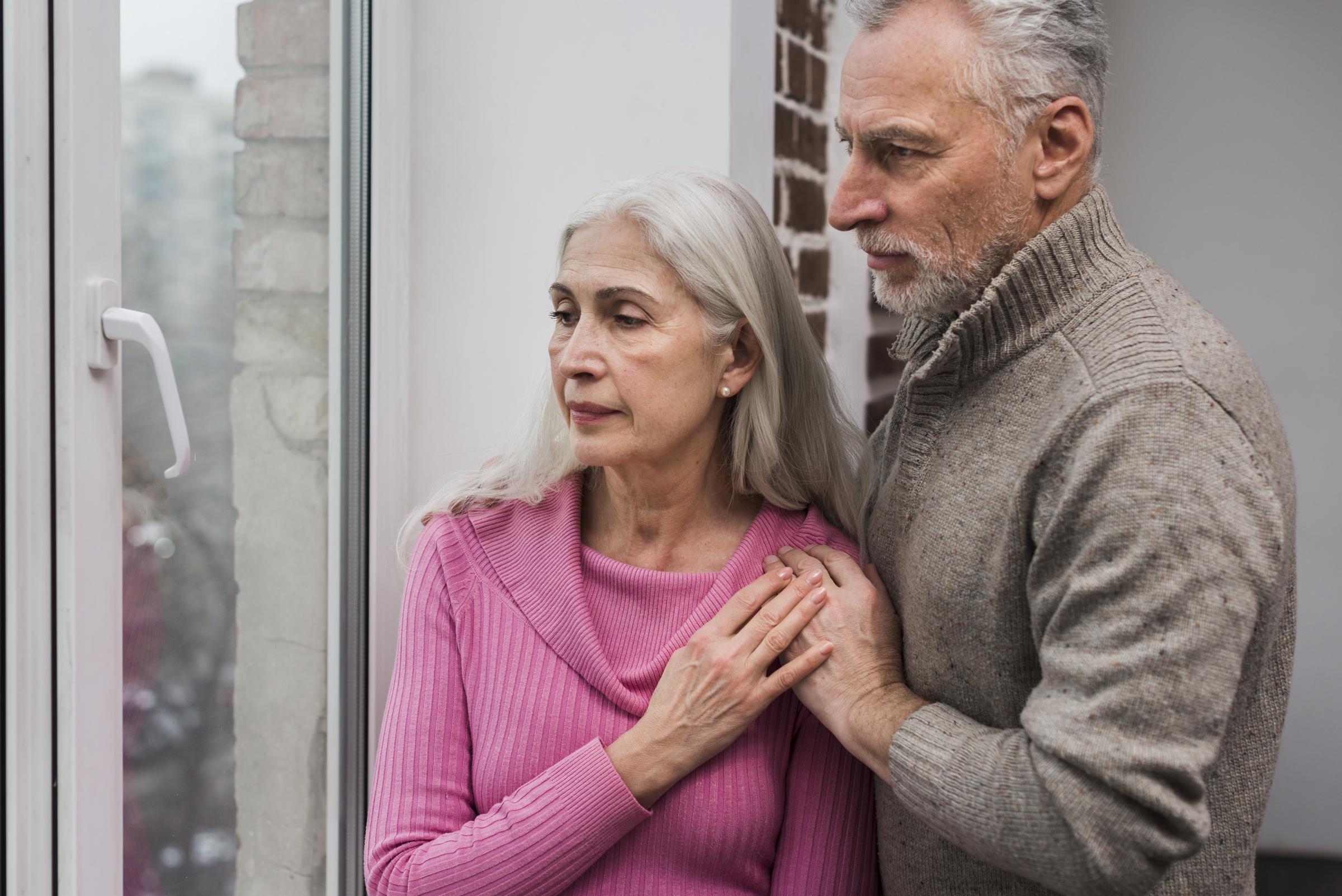 A senior couple looking out the window | Source: Freepik