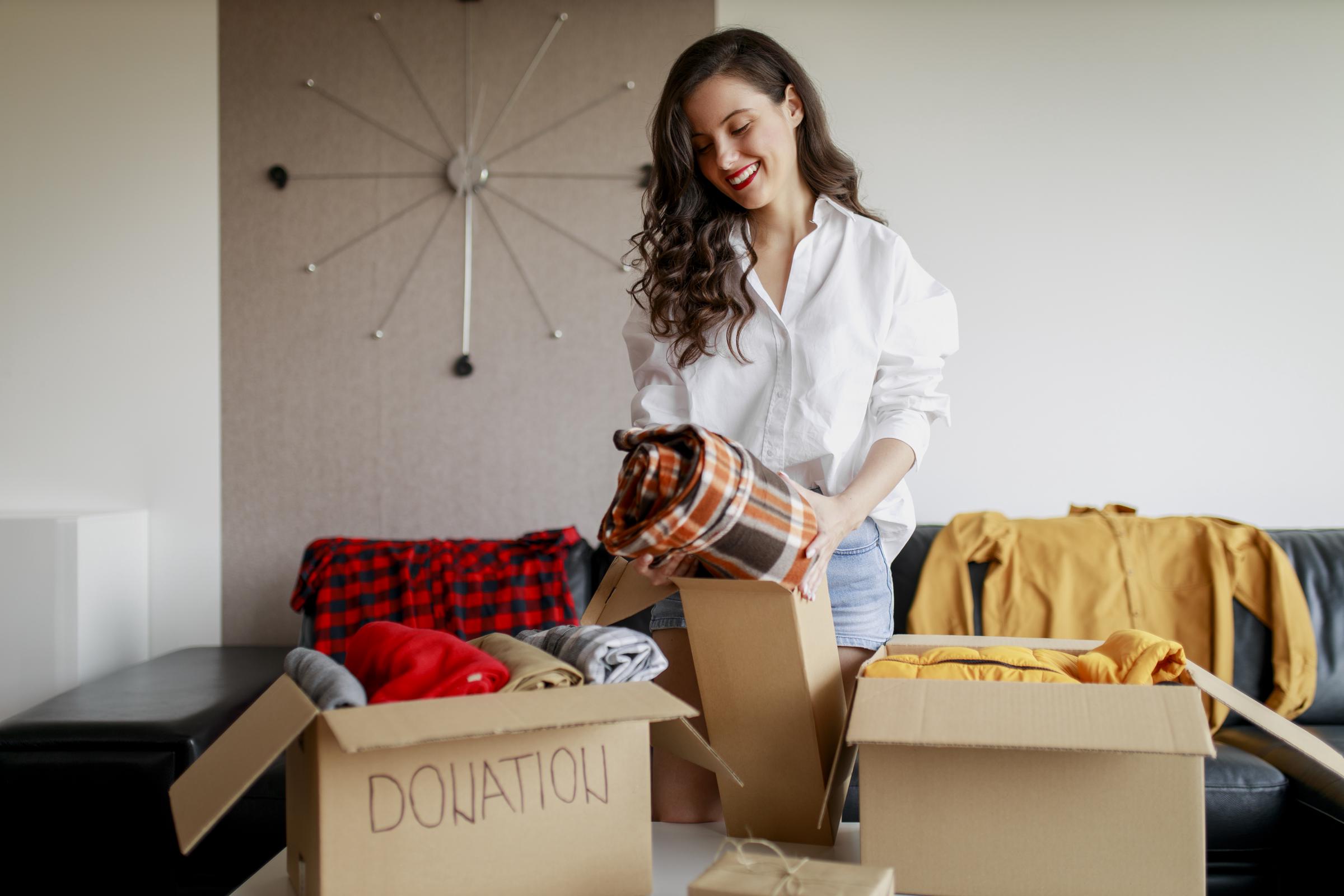 A woman packing clothes into a donation box | Source: Getty Images