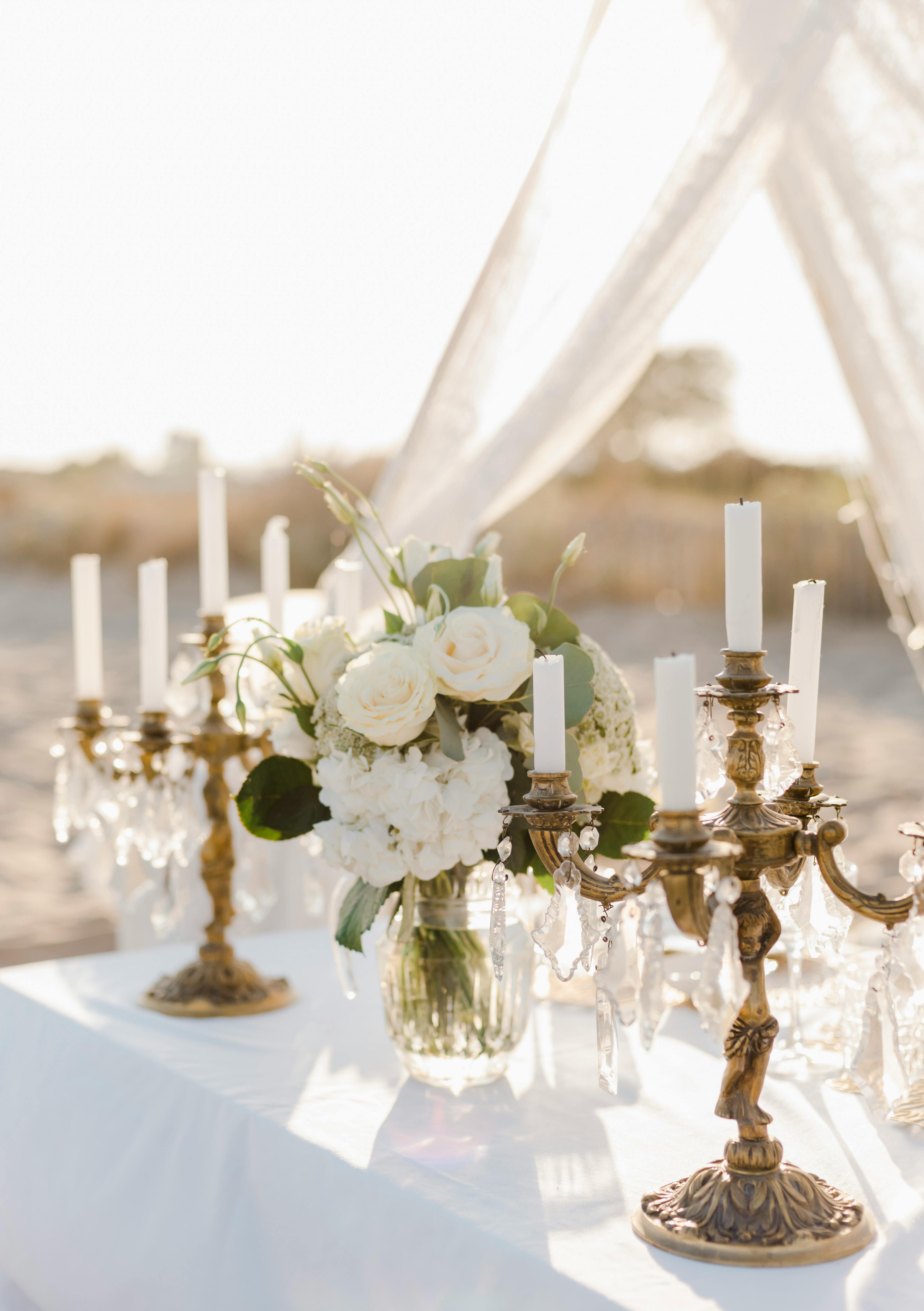 Candle holders and white bouquet in a vase | Source: Pexels