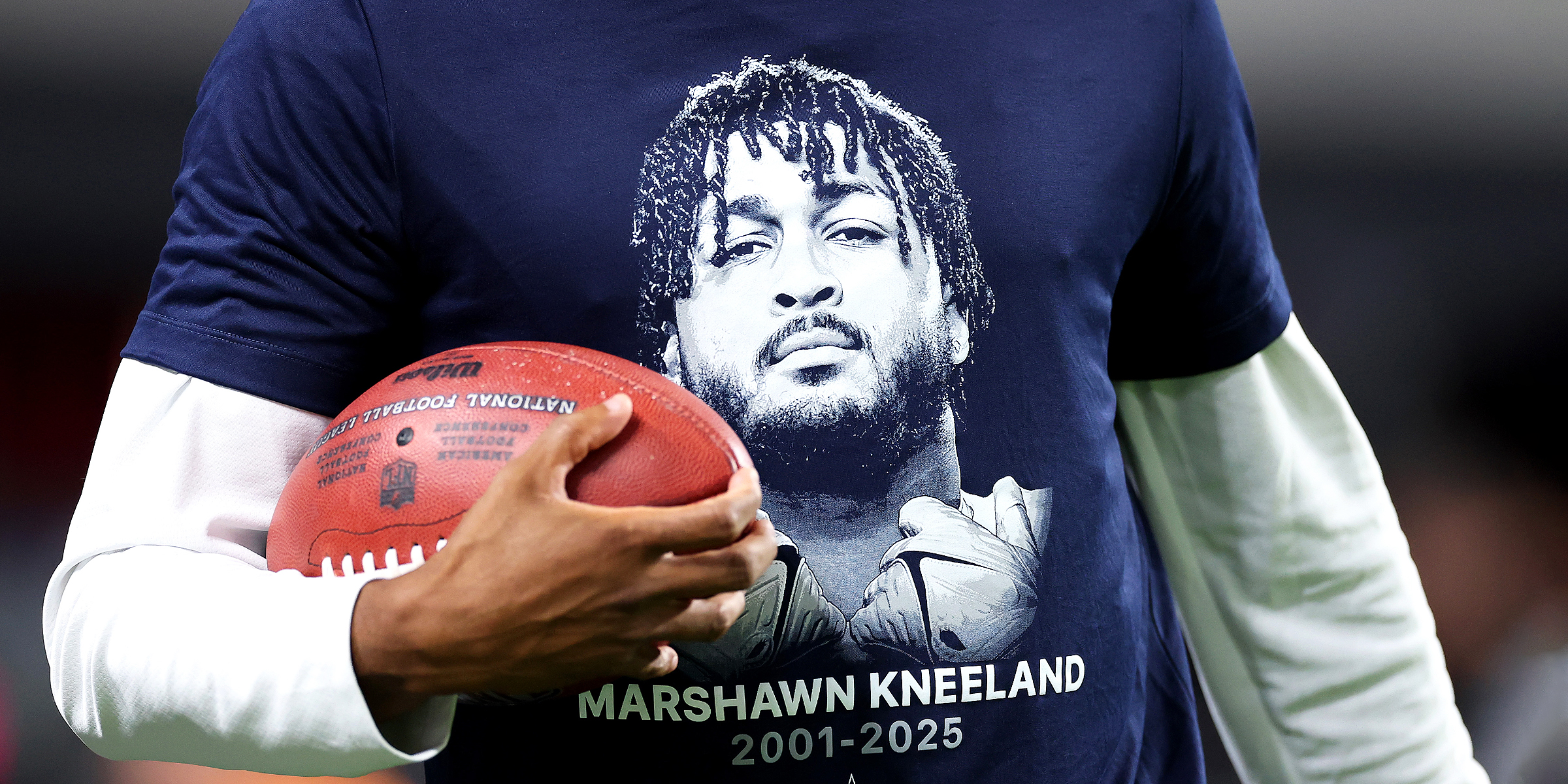 Someone wearing a t-shirt with an image of Marshawn Kneeland on it. | Source: Getty Images