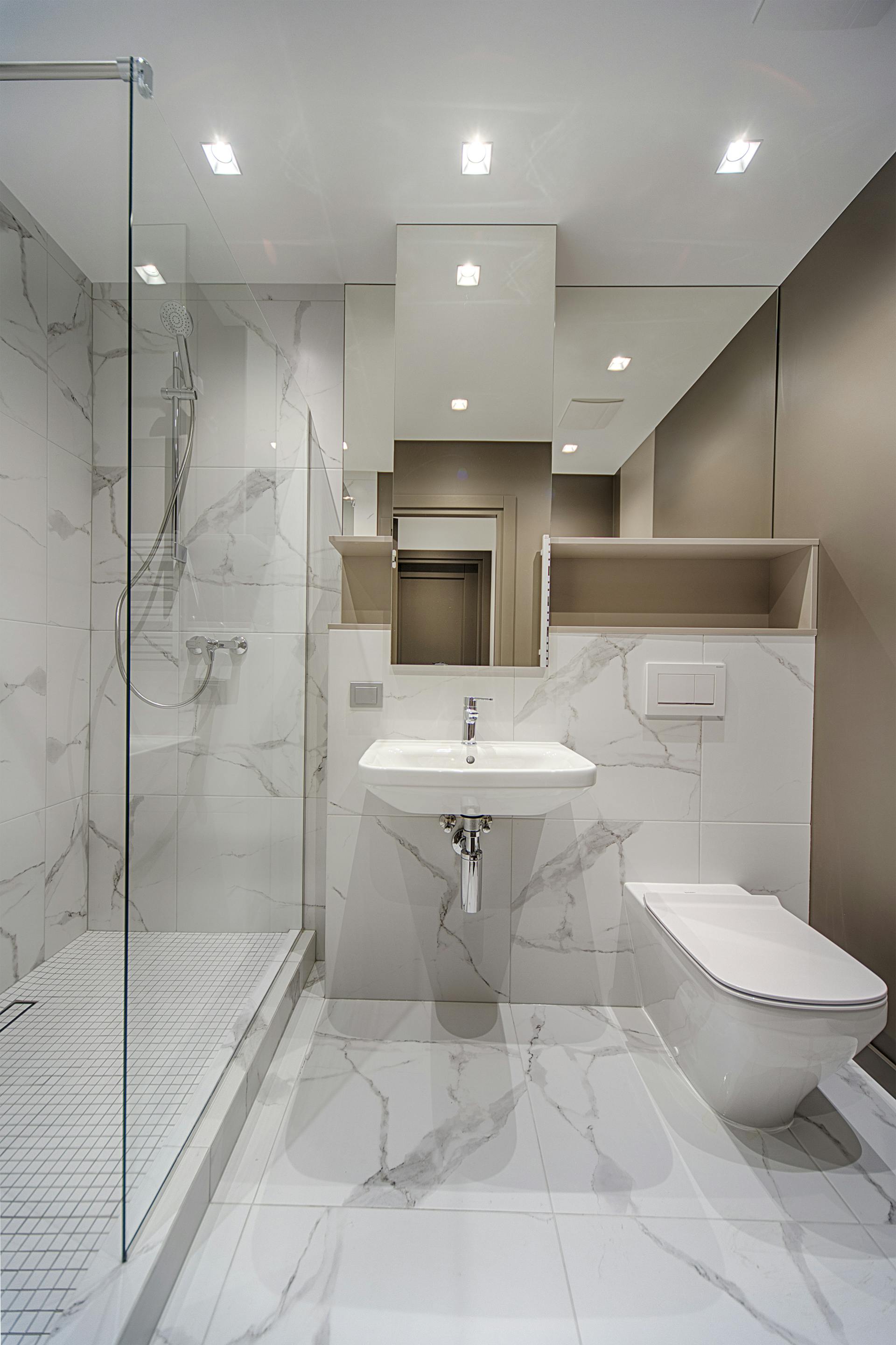 The marble interior of a bathroom with a wash basin and a toilet seat | Source: Pexels