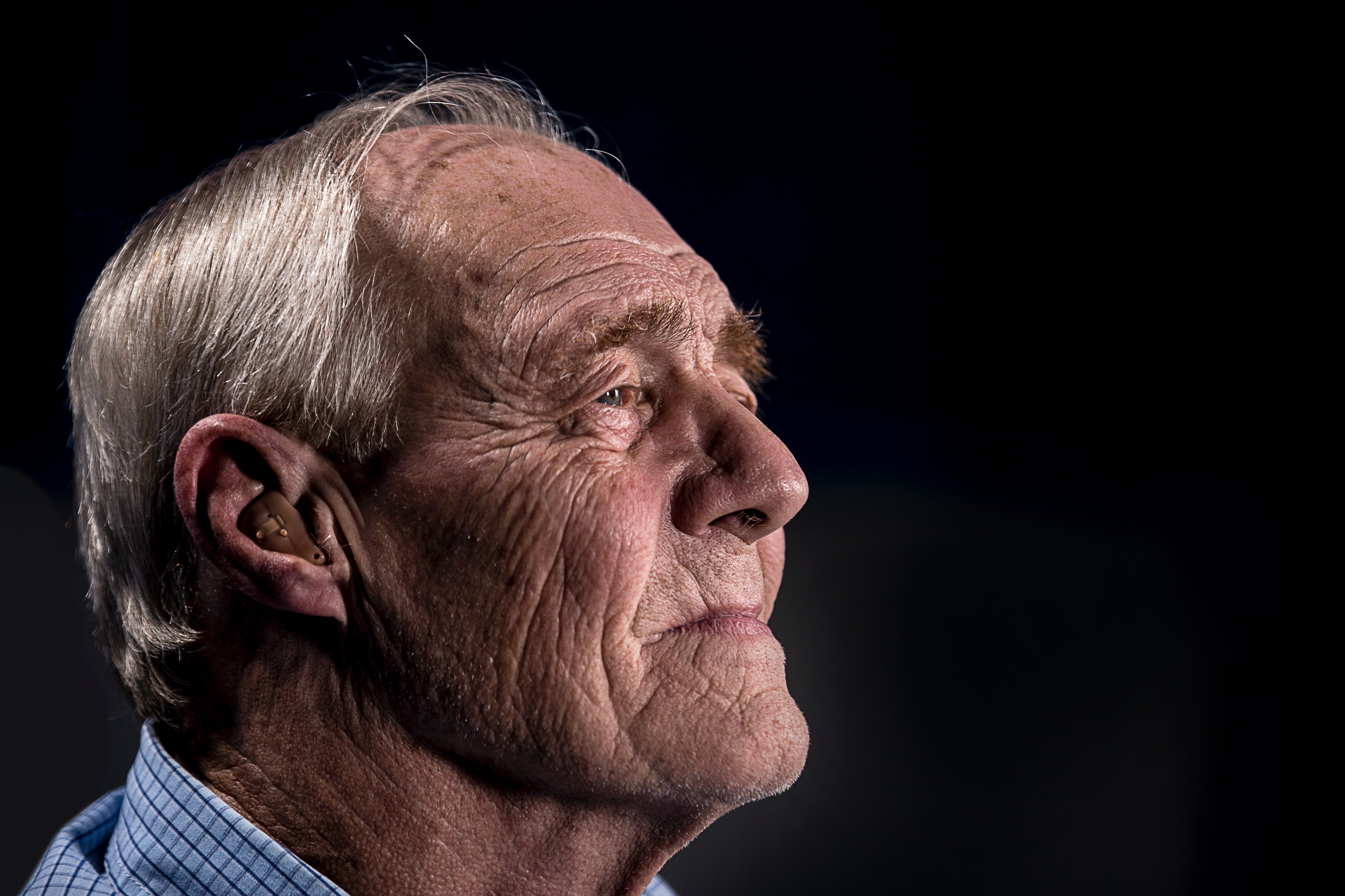 Un anciano posando de perfil mirando hacia un lado. | Foto: Unsplash