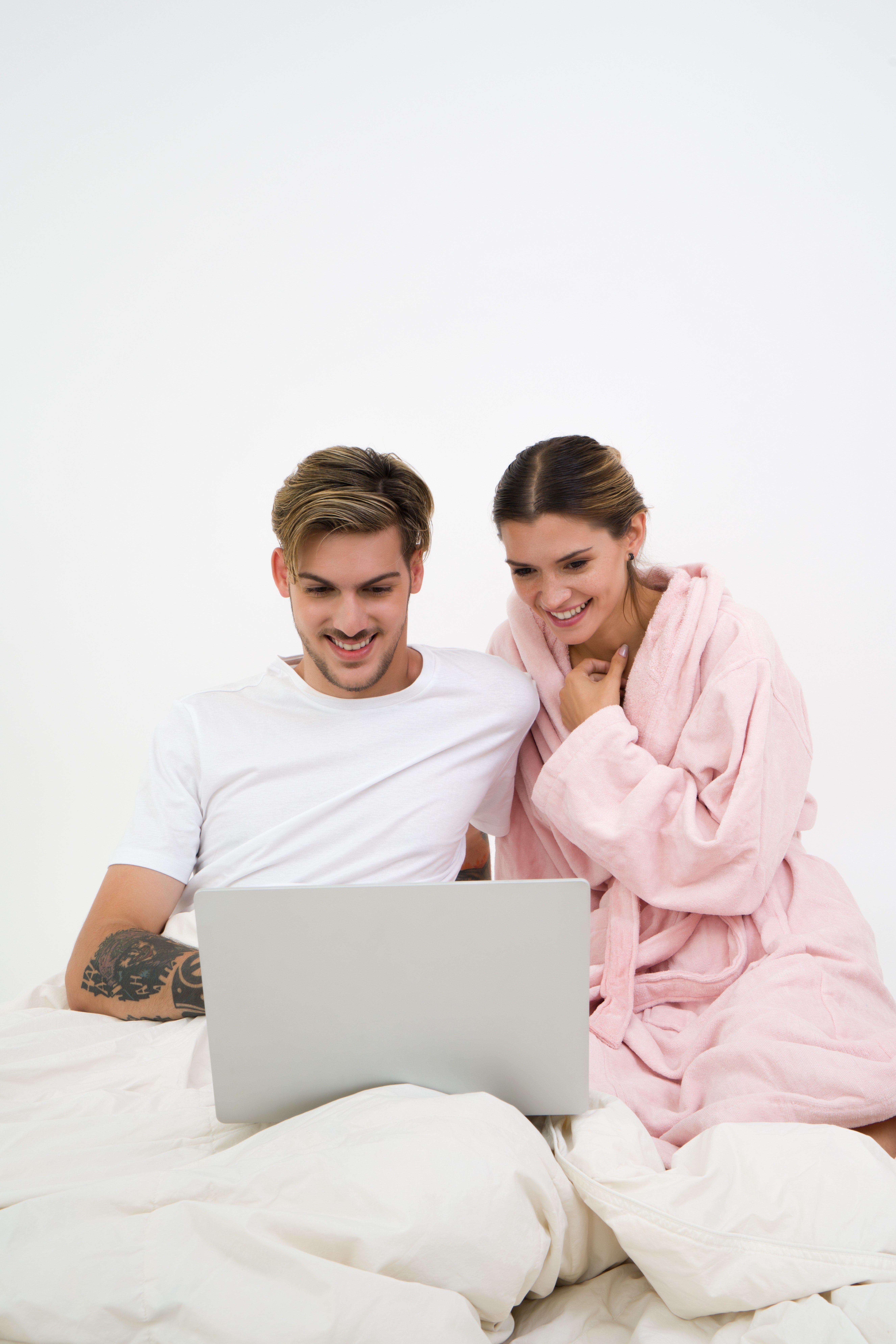 Pictured - A man and a woman sitting on the bed looking at the laptop | Source: Pexels 