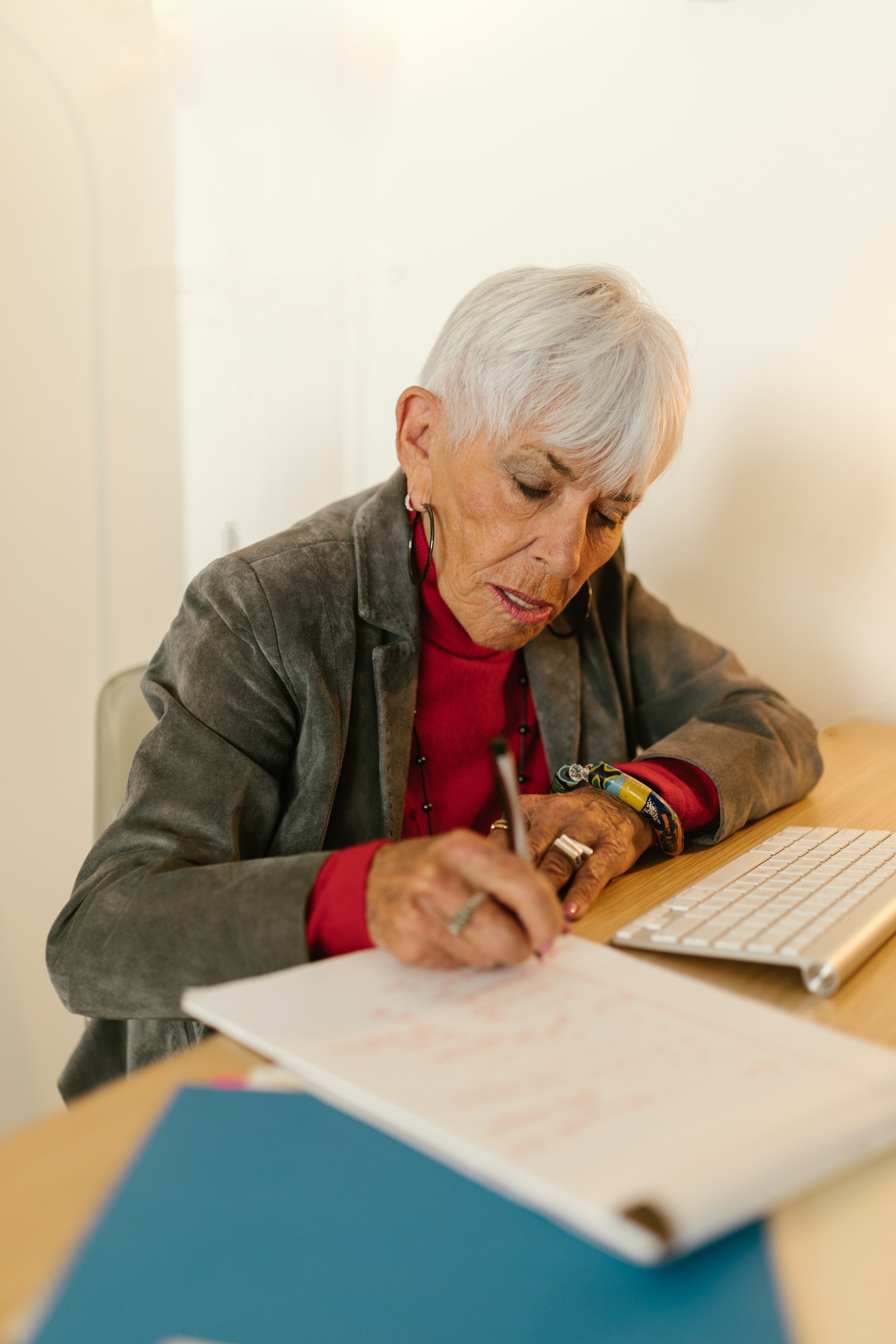 An older woman working on a desk | Source: Pexels