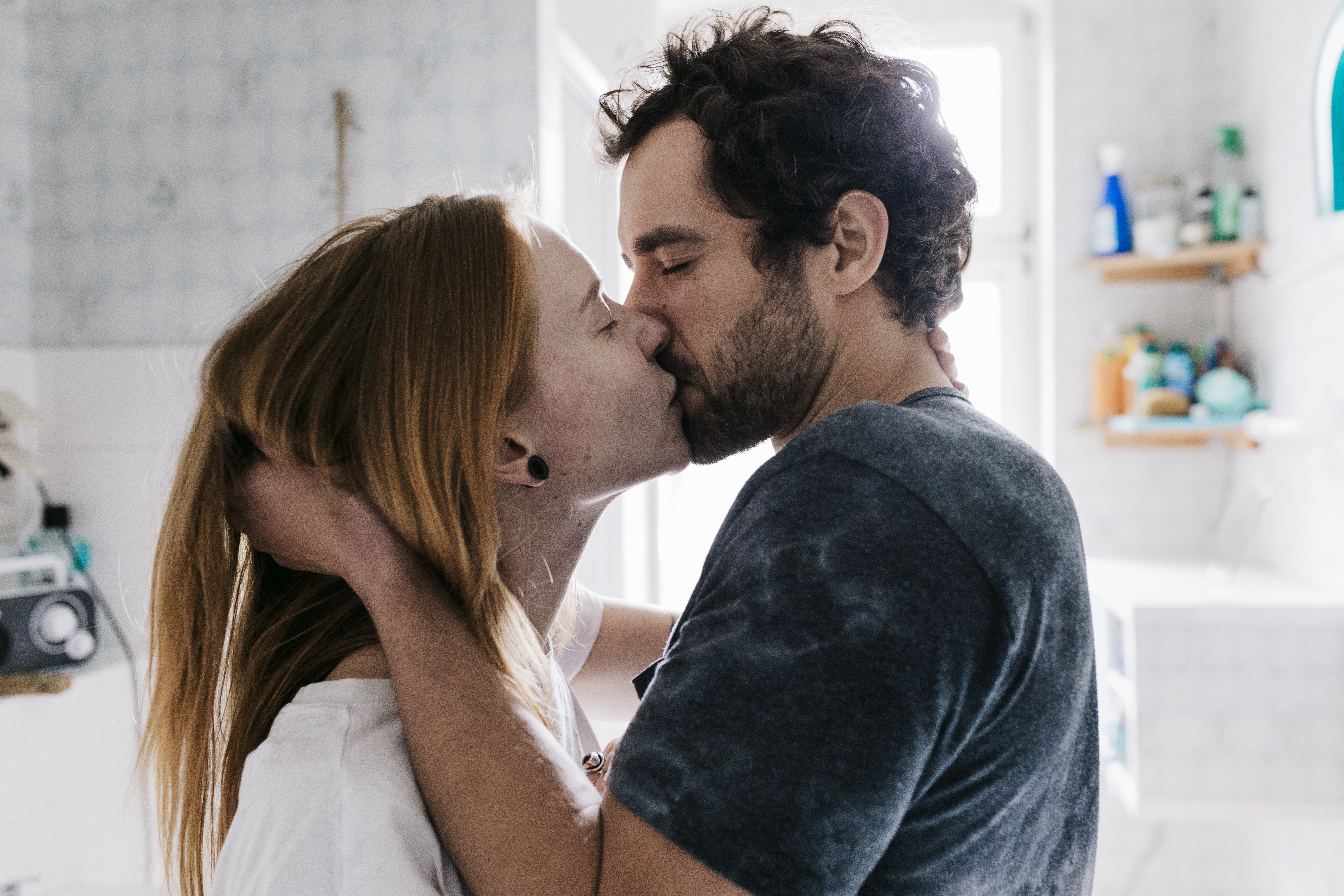 A man grabs the back of a woman's head and hair as they kiss passionately with their eyes closed | Source: Getty Images