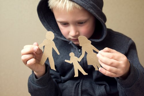 Child with broken paper family cut-out. | Source: Shutterstock.
