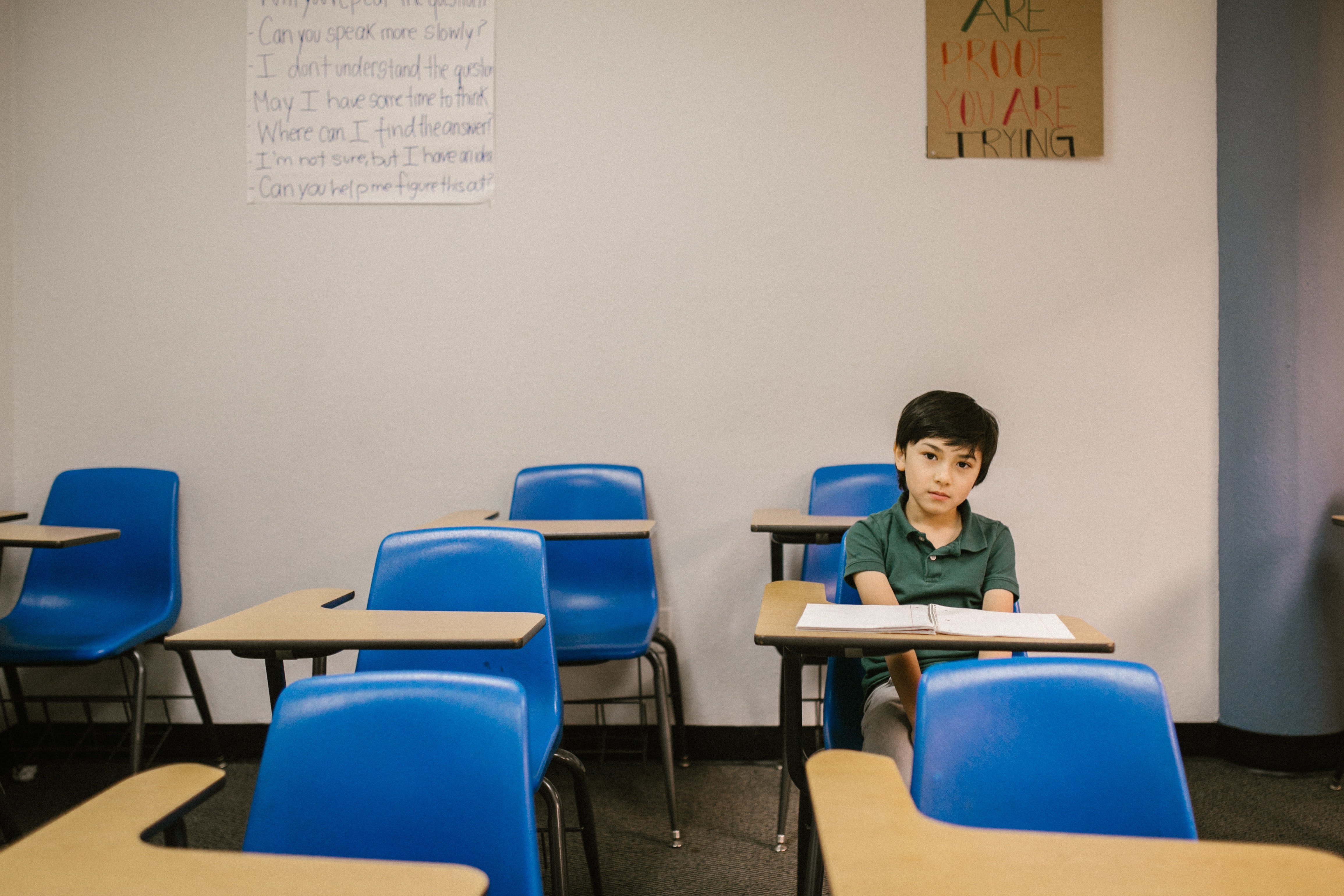 Boy sitting on his desk looking lonely | Photo: Pexels