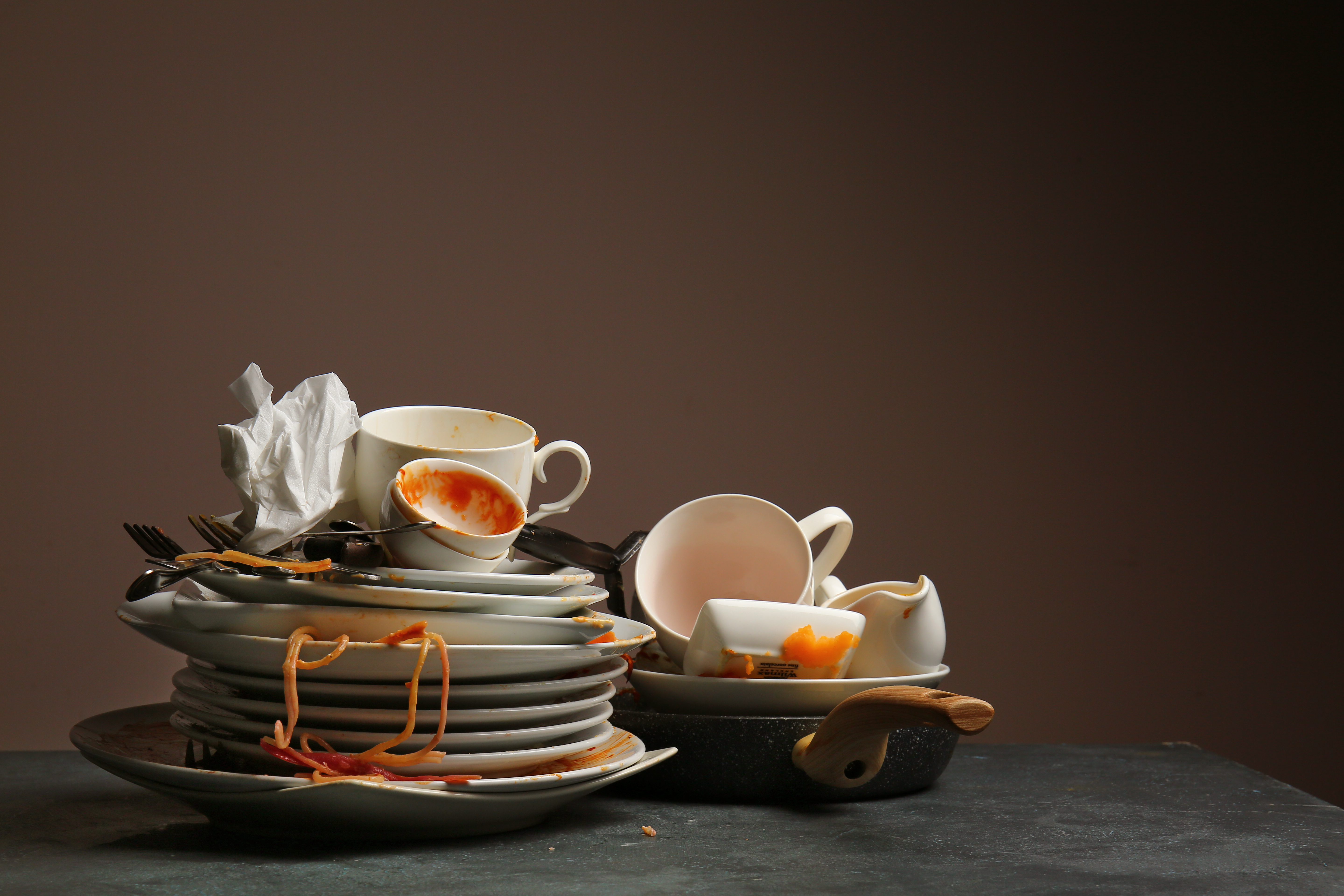 A pile of dirty dishes with a paper towel on top of them | Source: Shutterstock