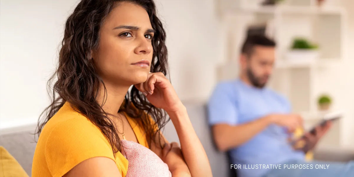 A serious woman lost in her thoughts while sitting next to her partner | Source: Shutterstock