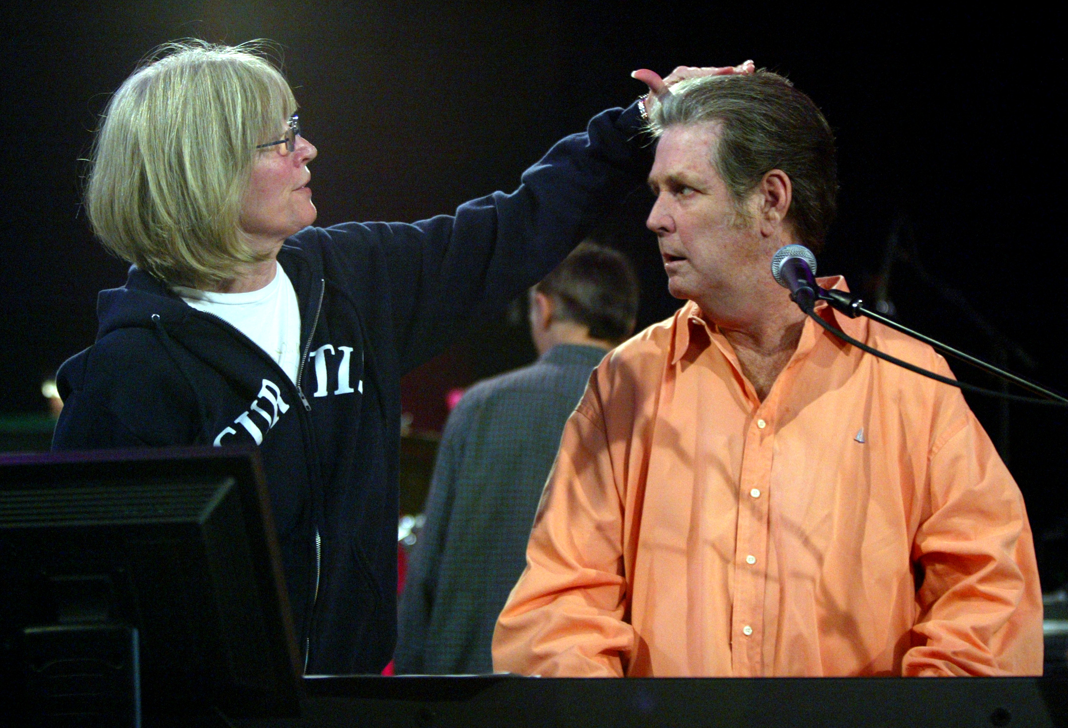 Melinda Wilson fixes her husband and former Beach Boys member Brian Wilson's hair as he rehearses in Los Angeles in 2004. | Source: Getty Images