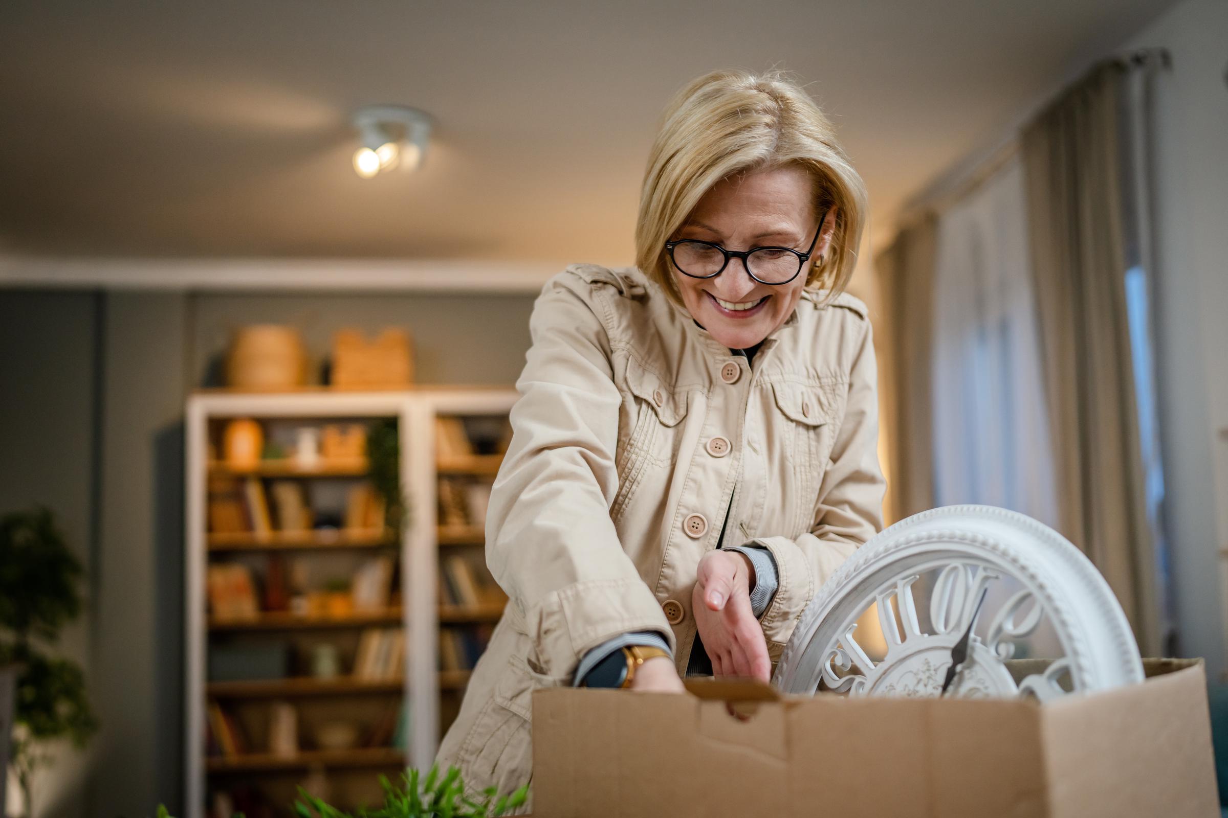 Woman happily packing things in a box | Source: Shutterstock
