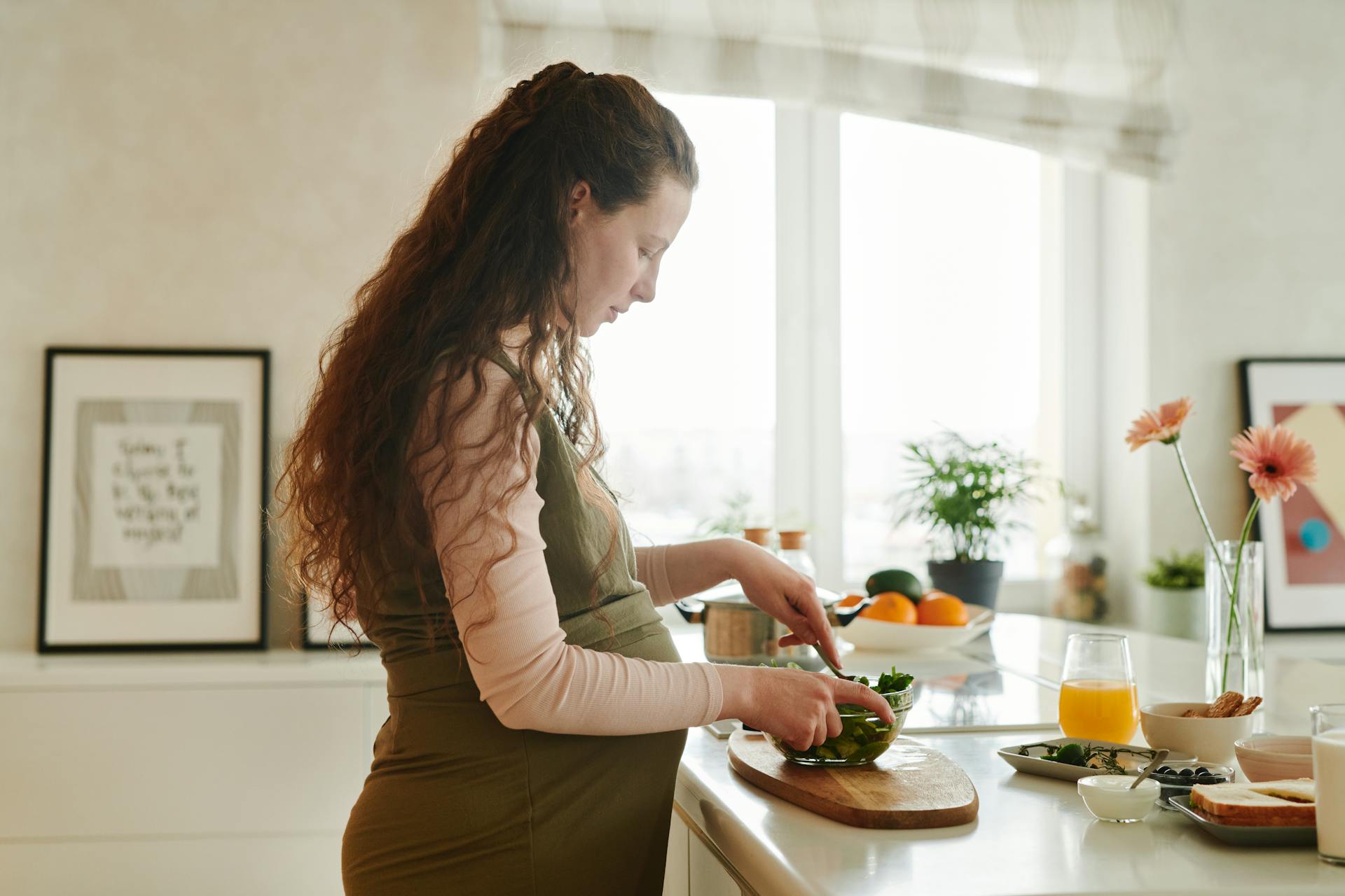 A pregnant woman preparing food on the kitchen counter | Source: Pexels