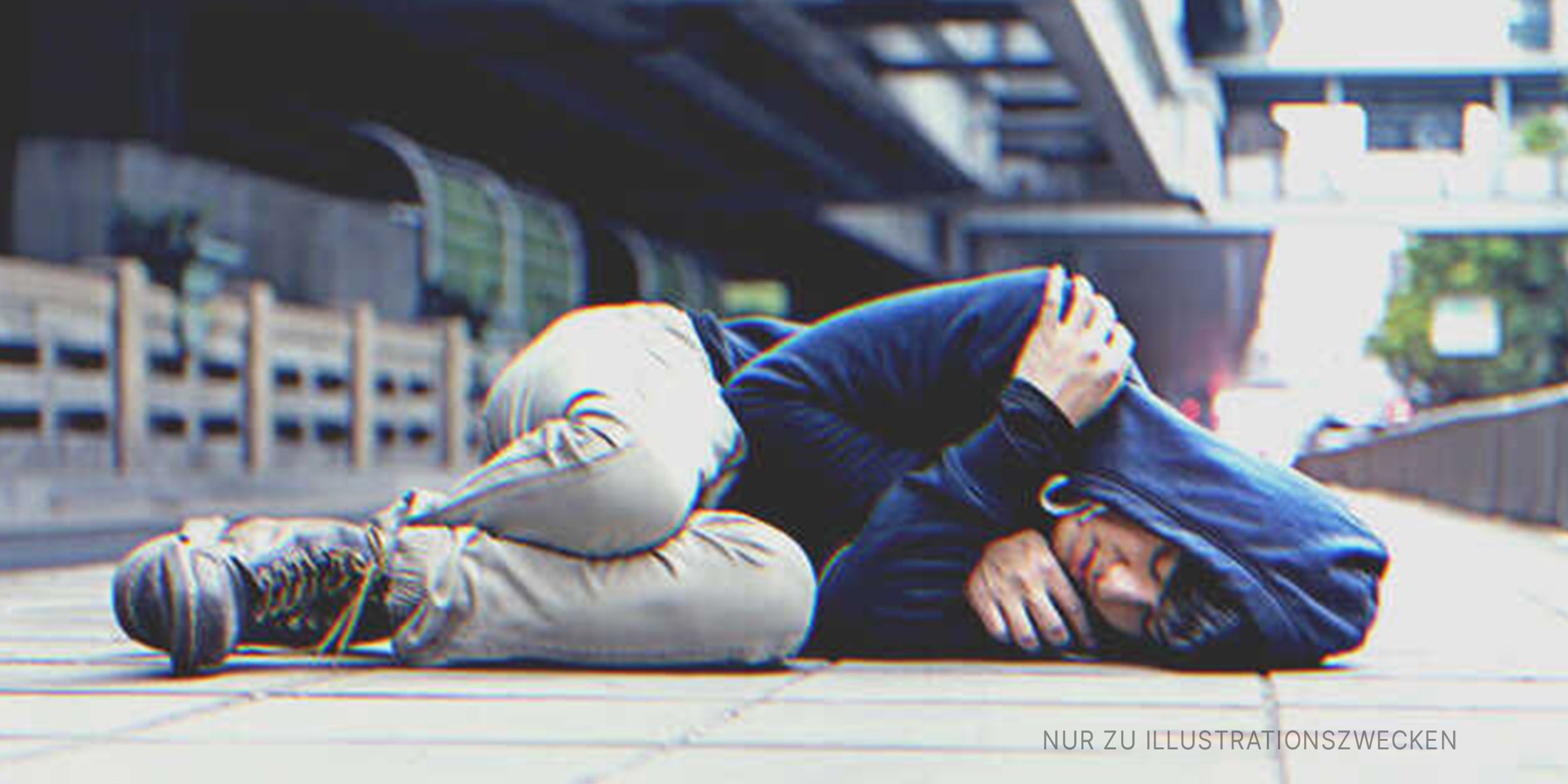 Ein schlafender Junge auf einem Bürgersteig. | Quelle: Shutterstock