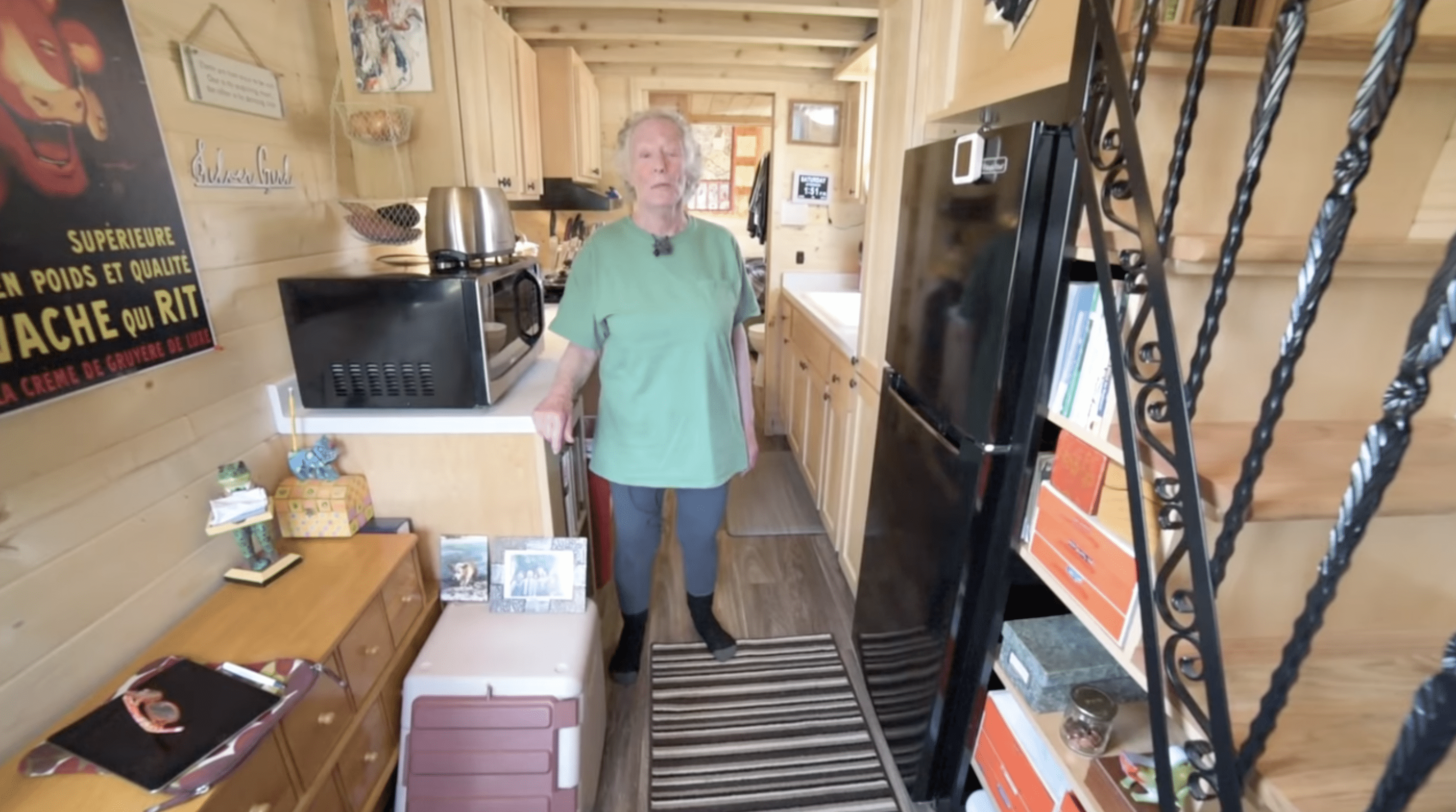 Penny stands in her tiny setup's living area. | Source: YouTube.com/TinyHomeTours