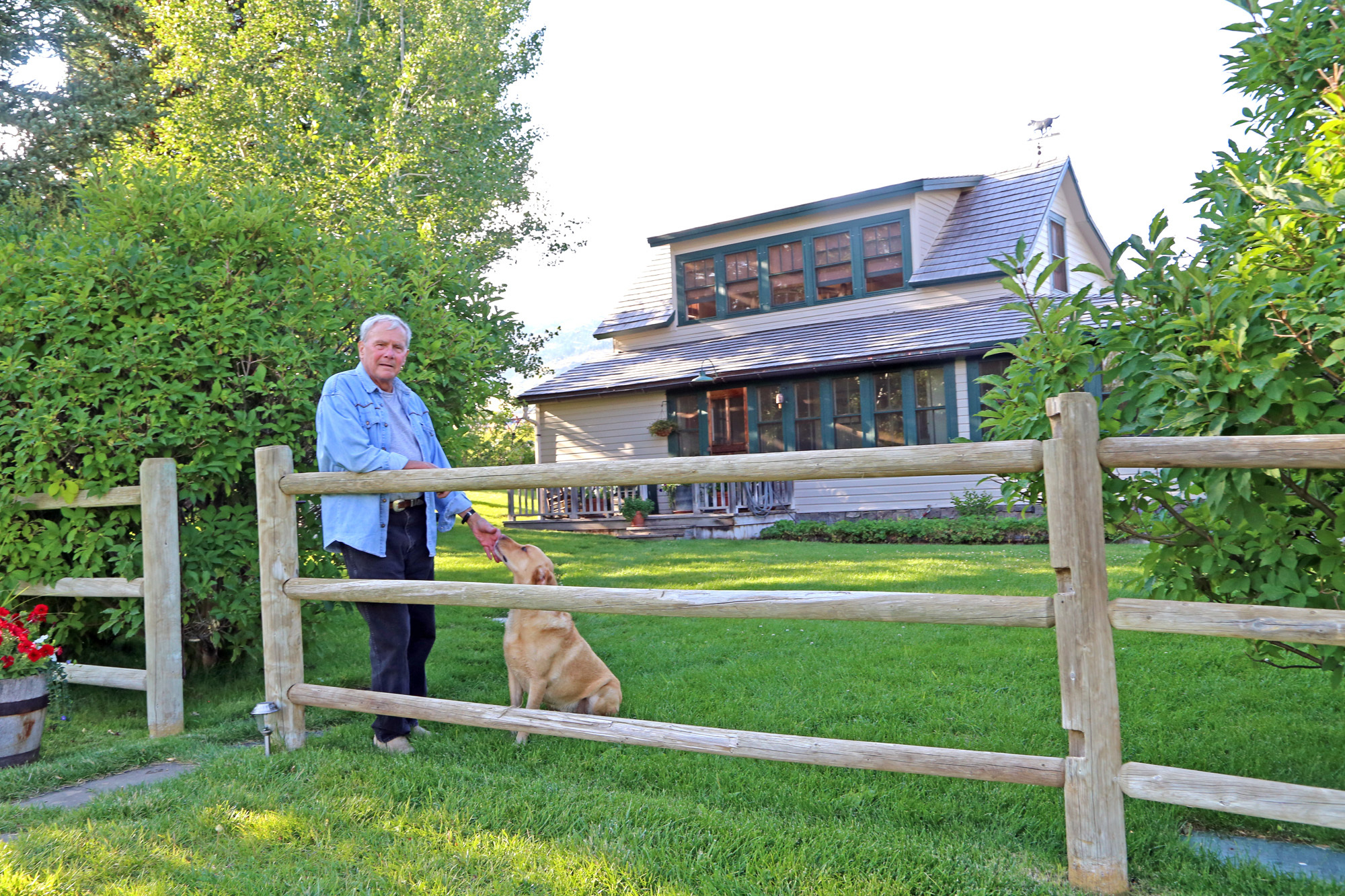 Tom Brokaw with his Labrador, Red, on his 5000-acre Montana ranch on August 16, 2014 | Source: Getty Images