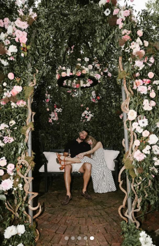 A garden of love! Taylor Swift leans into Travis Kelce beneath a romantic arch of roses and greenery, as posted on August 26, 2025 | Source: Instagram/taylorswift