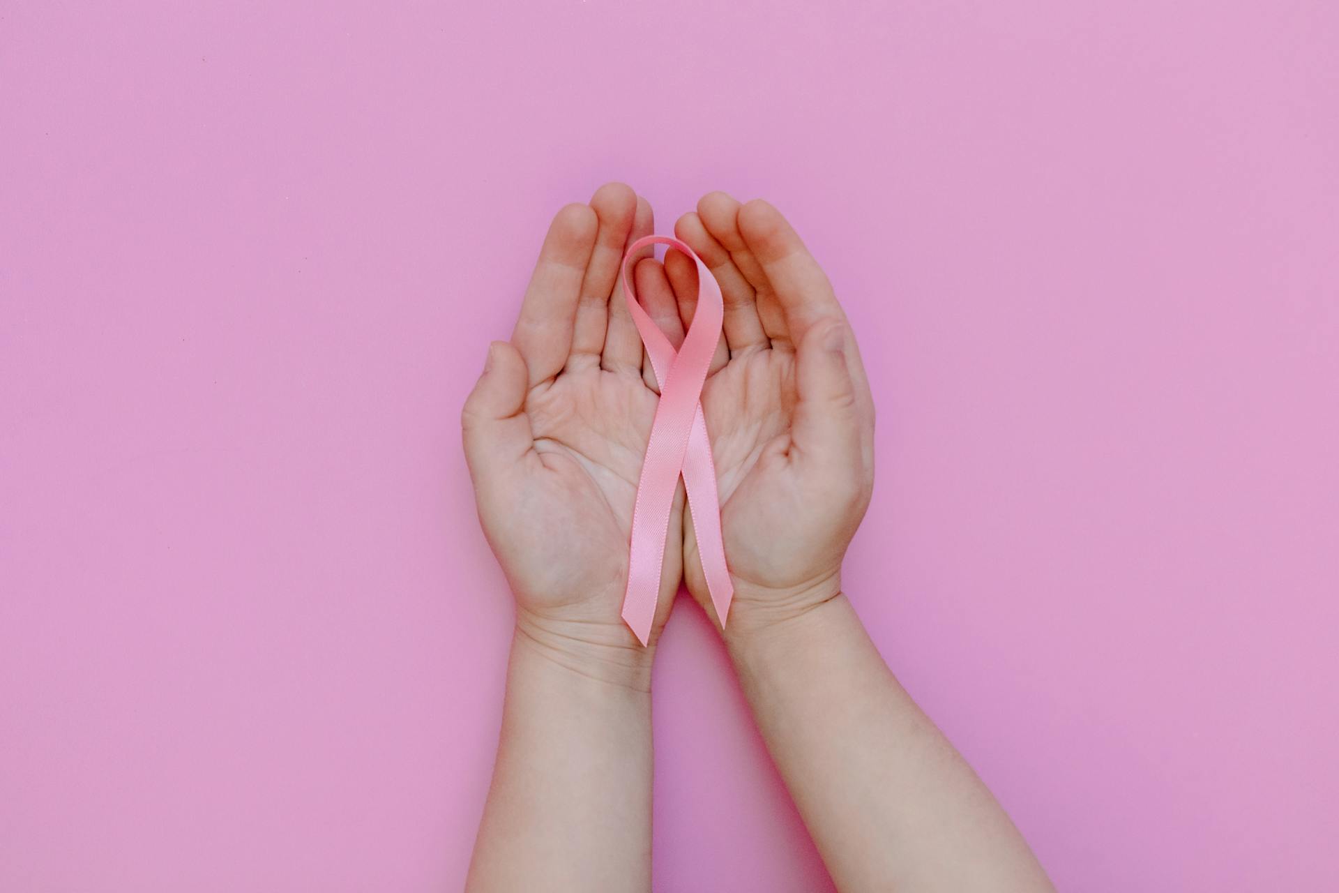 A person holding a pink ribbon | Source: Pexels