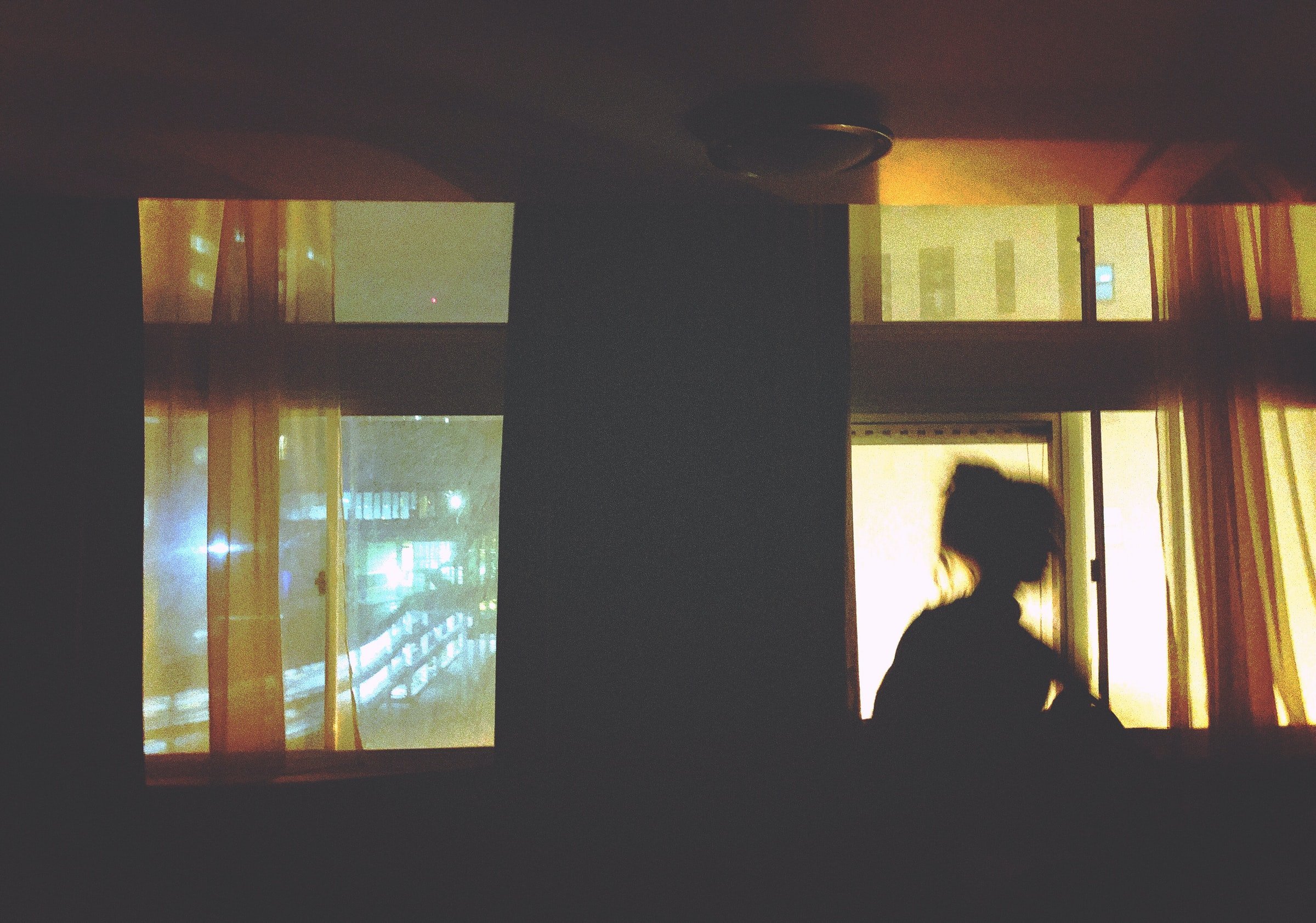 Die Silhouette einer Frau in einem dunklen Raum. | Quelle: Unsplash