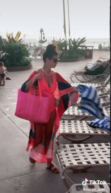 A woman placing water bottles and towels on top of lounge chairs to reserve them. | Source: tiktok.com/sarah_jade