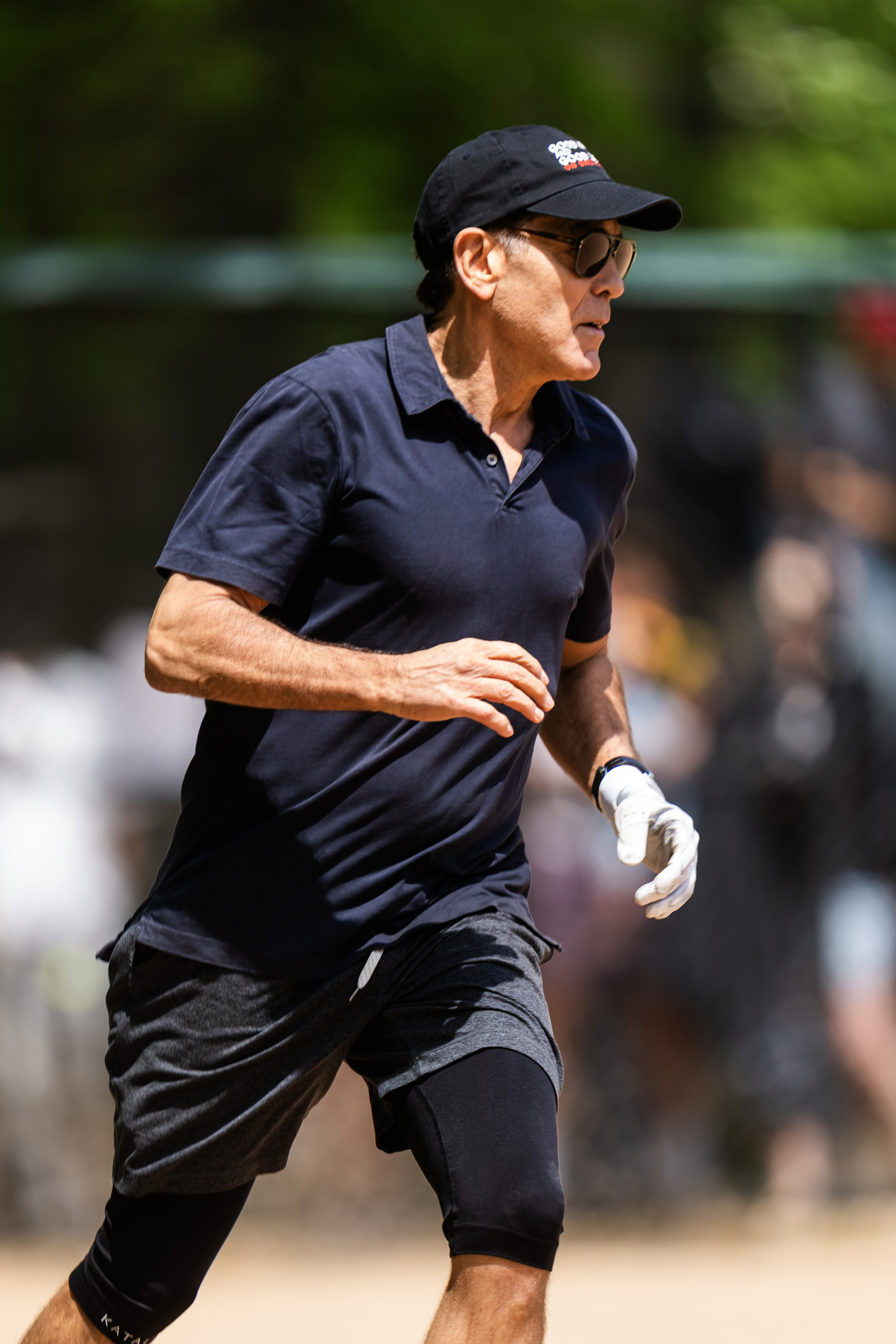 Clooney runs with purpose, his expression calm and steady as he moves across the field. It’s a quiet moment of concentration in the middle of the action.