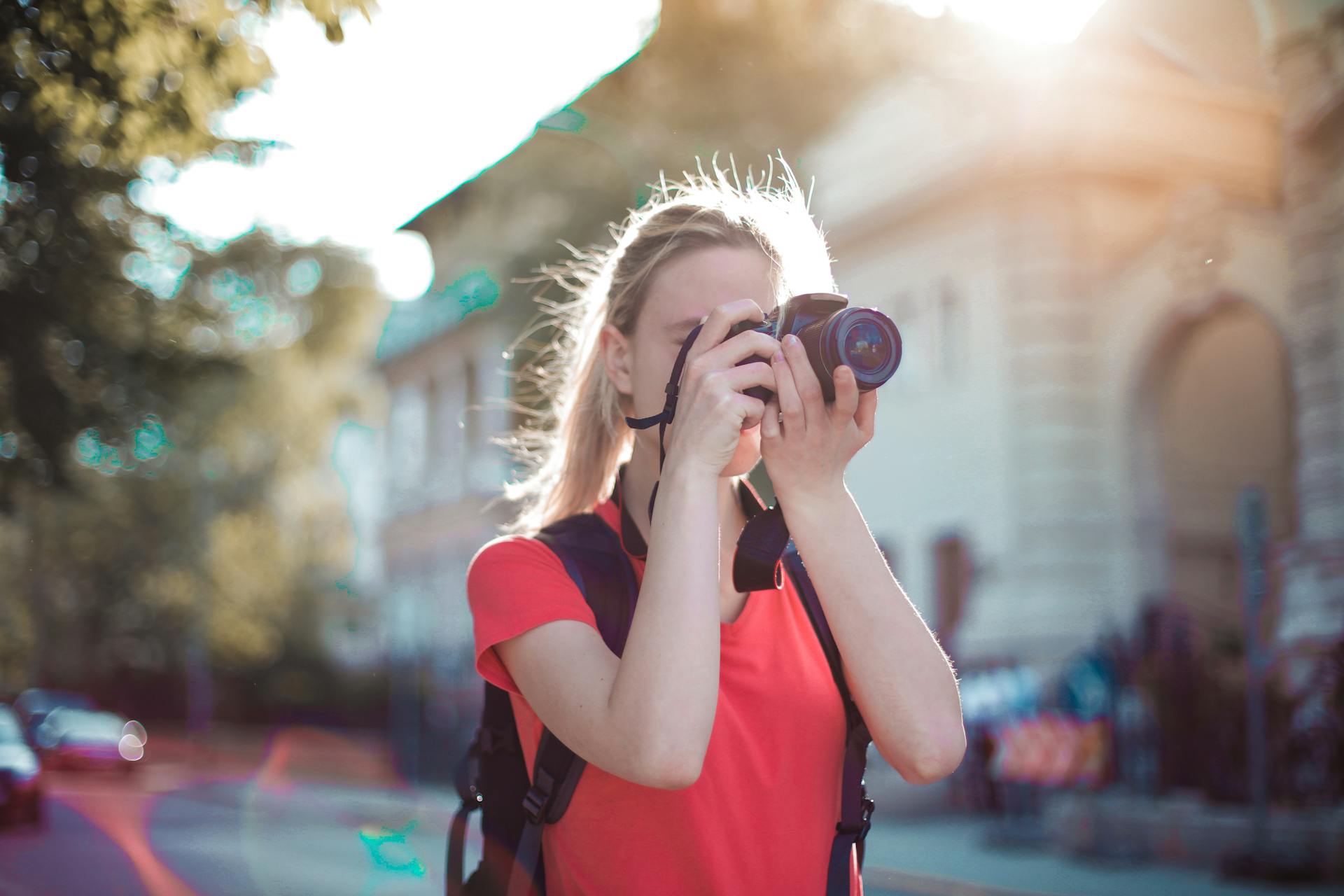 A woman clicking a picture using a DSLR camera | Source: Pexels