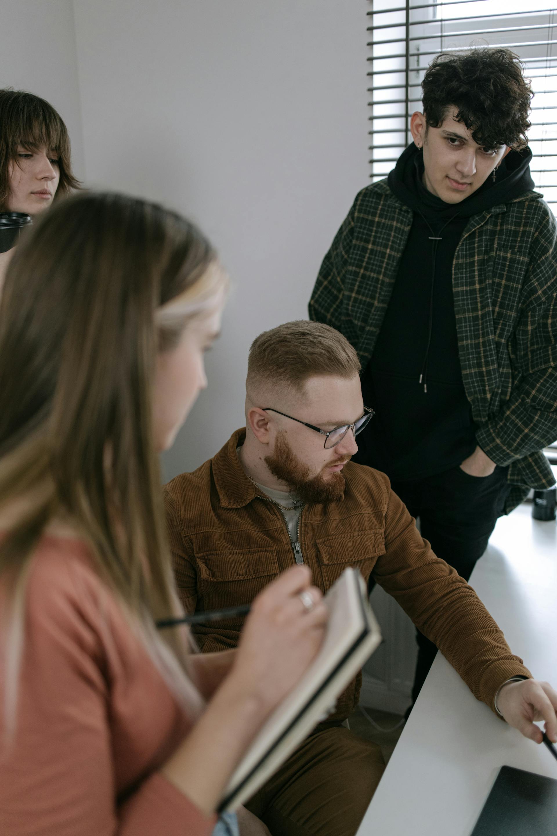 A young man looks at his other team members during a group project discussion | Source: Pexels