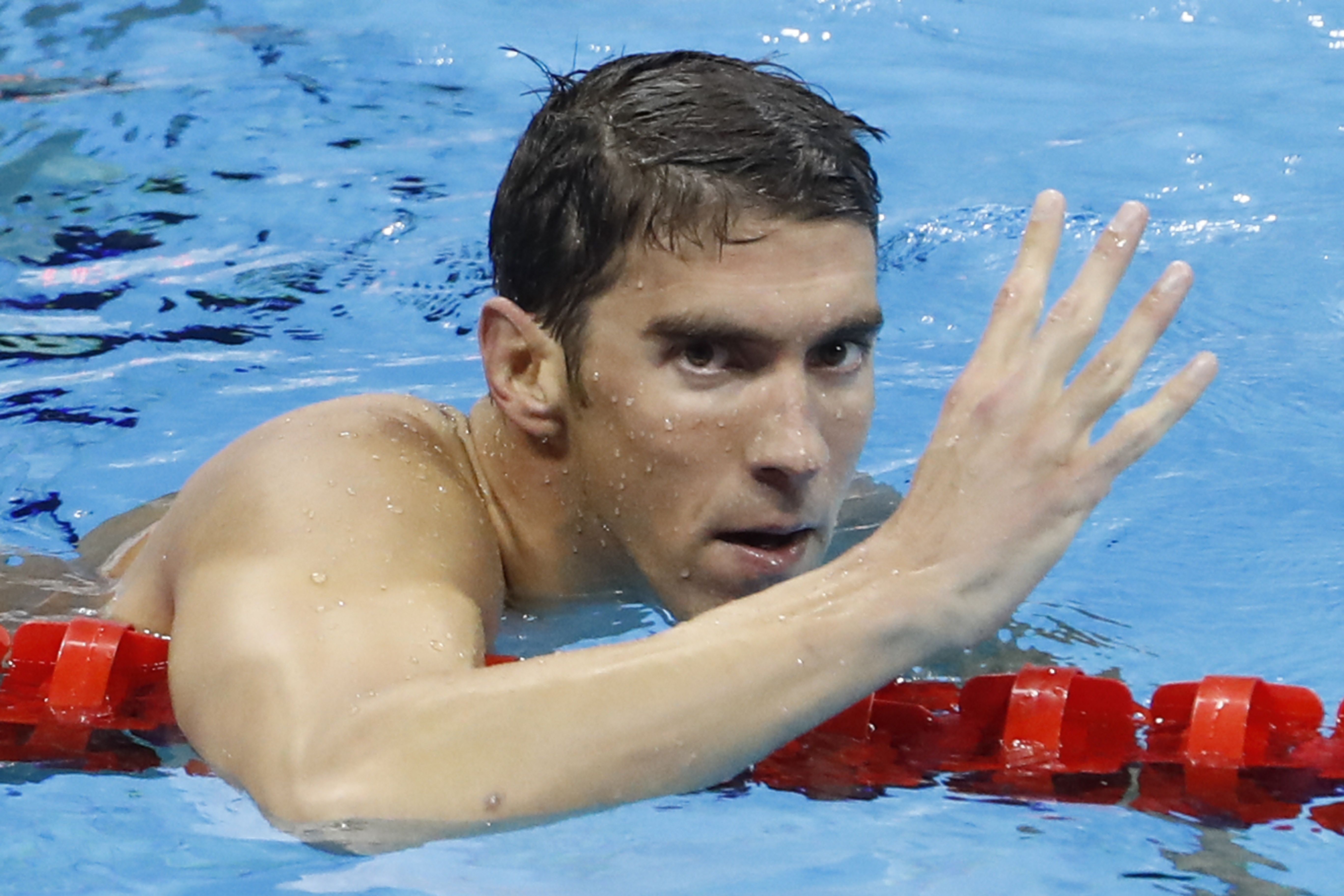 Michael Phelps celebrates his fourth gold medal with a hand gesture after his victory in the Mens 200m Individual Medley Final at the Rio 2016 Olympic Games | Source: Getty Images