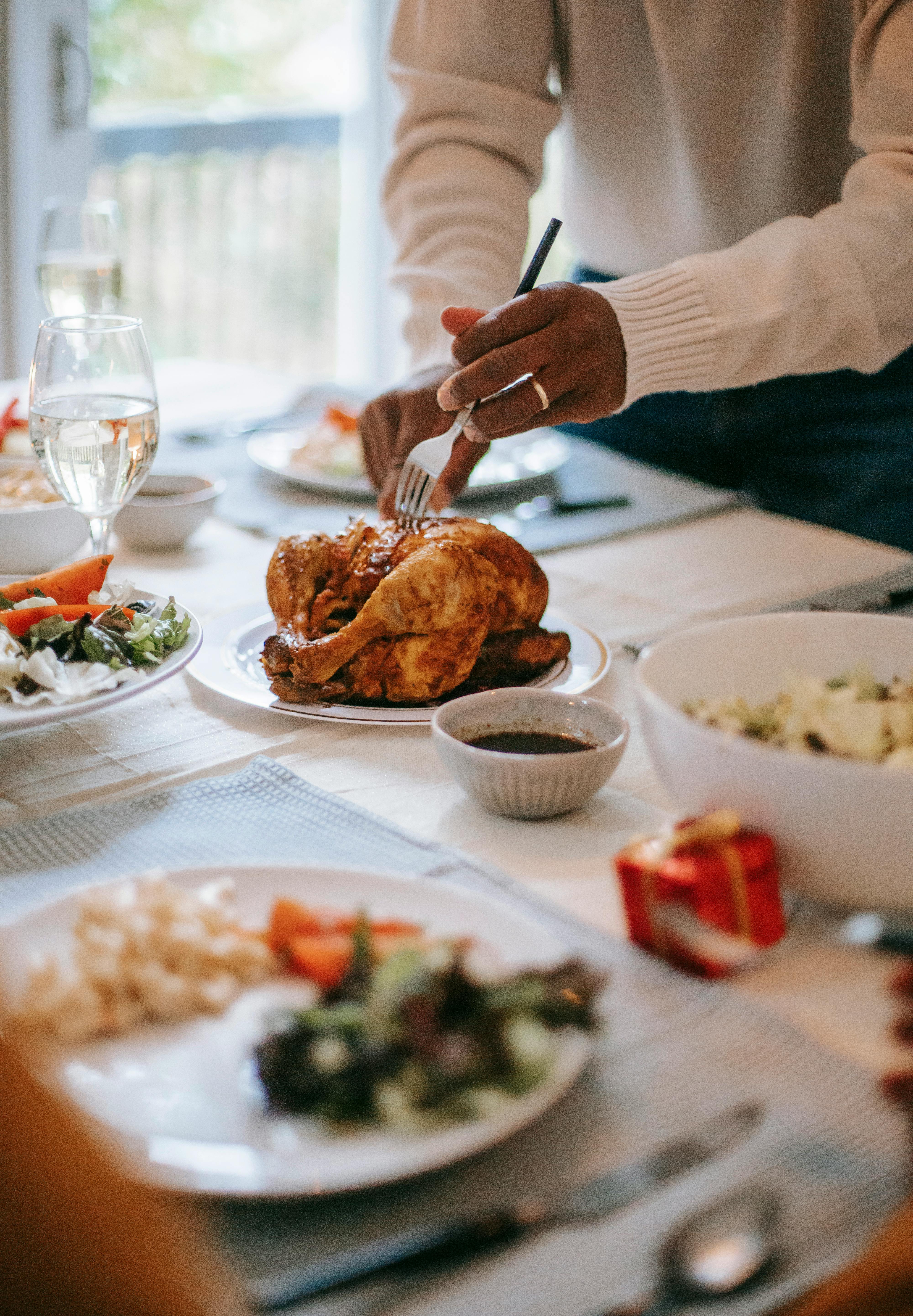 A person cutting chicken | Source: Pexels