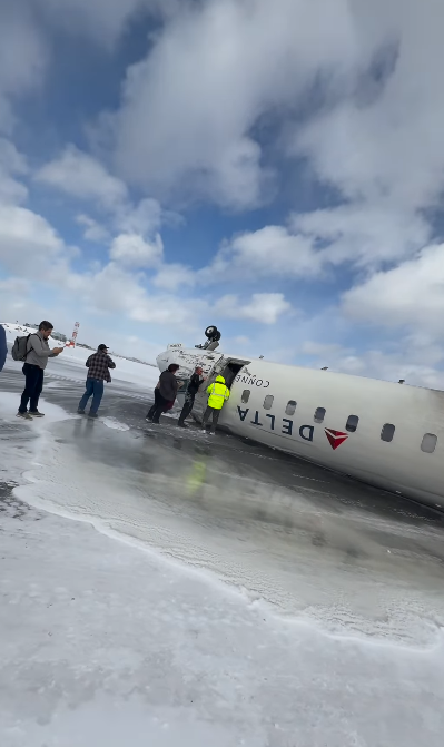 More passengers exit the damaged Delta plane onto the snow-covered ground as others assist in the evacuation | Source: Instagram.com/eggxit