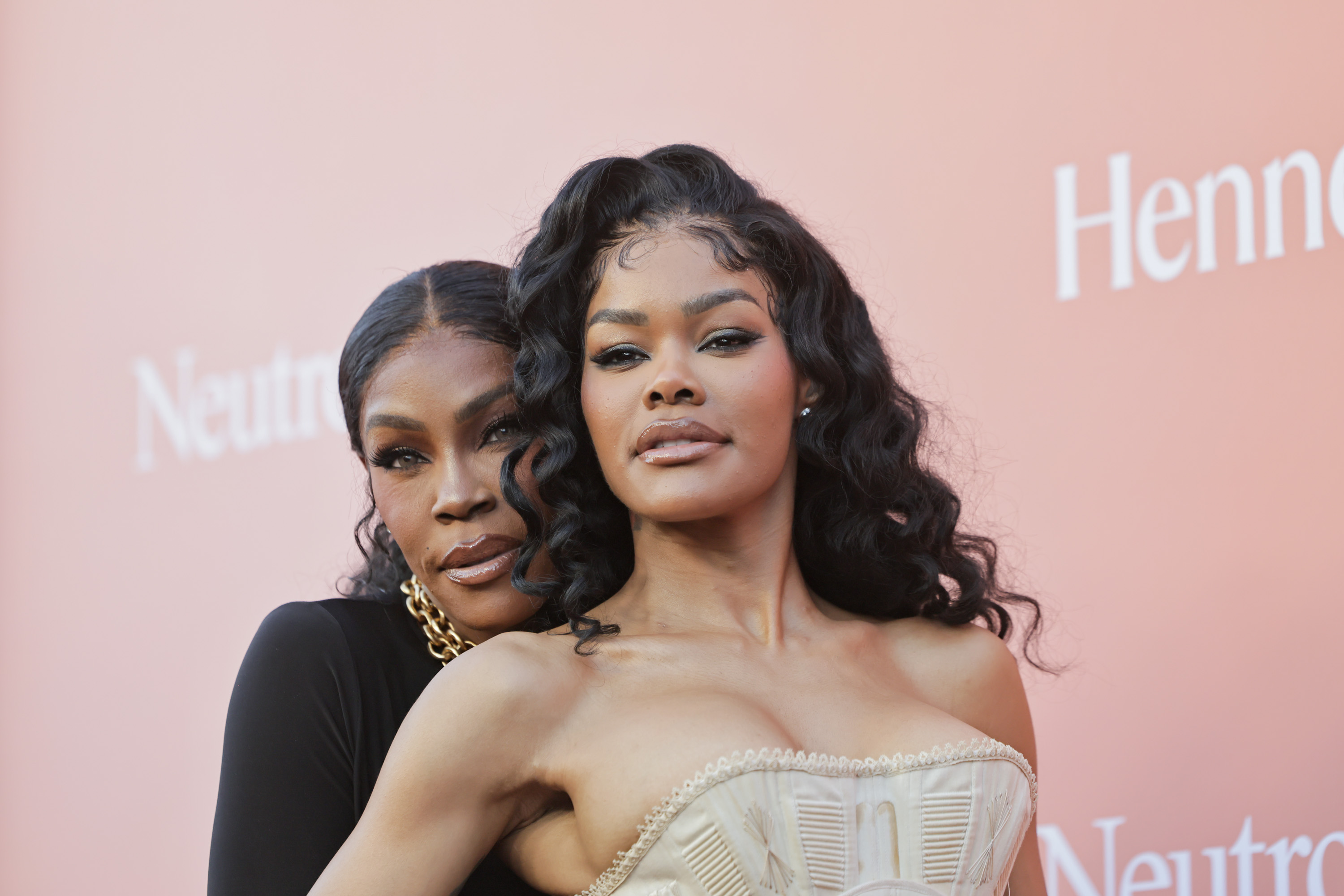 Teyana Taylor poses alongside Nikki Taylor, who stands just behind her in a sleek black look | Source: Getty Images