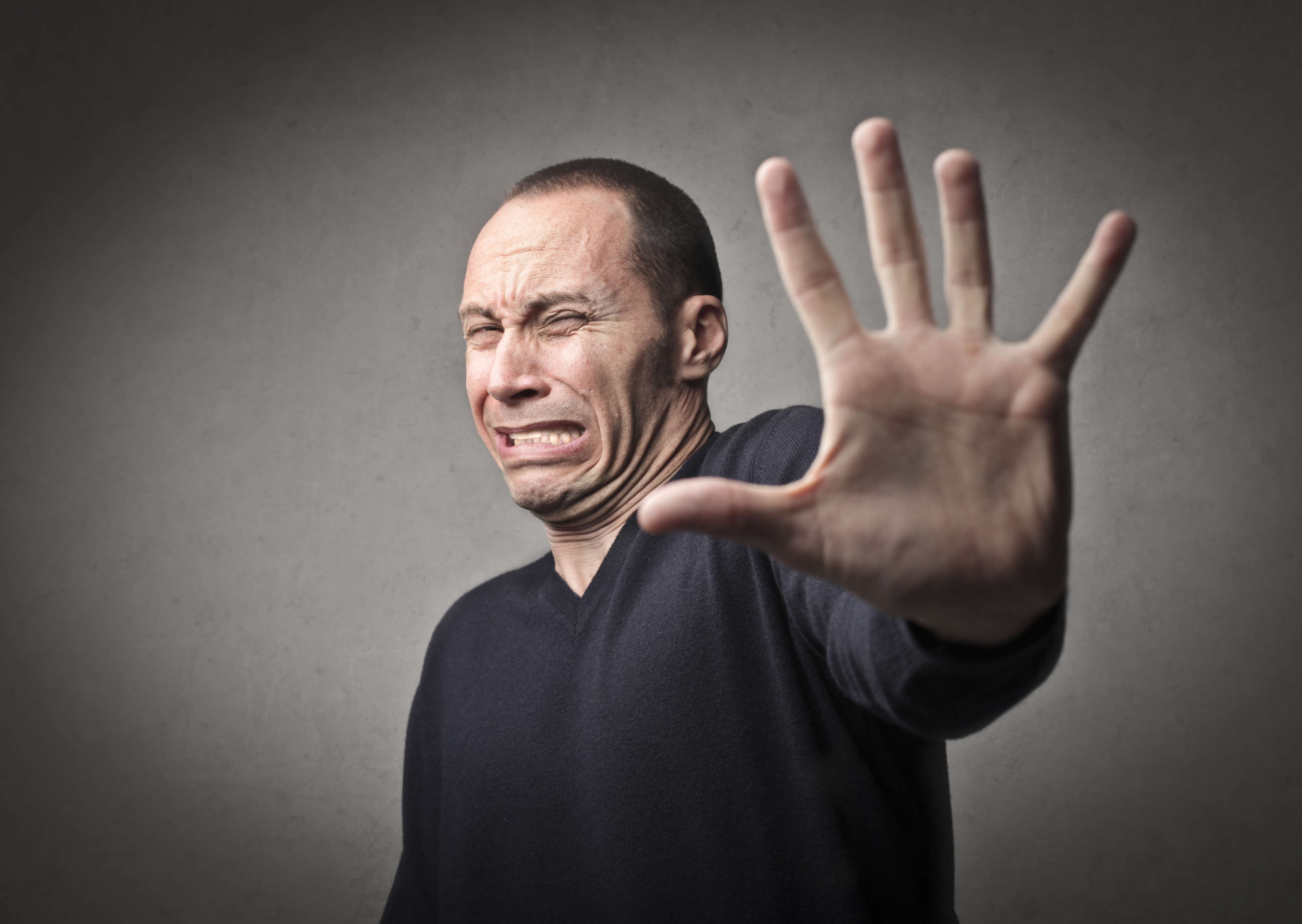 Scared man indicating to halt with his hand | Source: Shutterstock.com