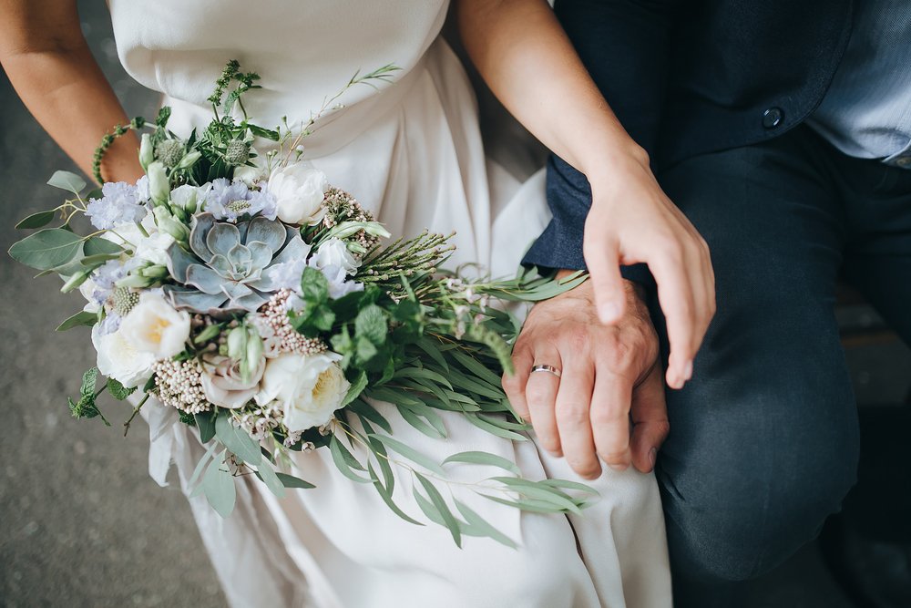 Pareja en su boda tomada de la mano. | Foto: Shutterstock