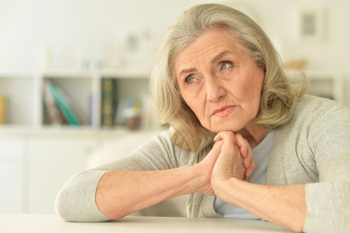 Ältere Dame schaut nachdenklich drein | Quelle: Shutterstock