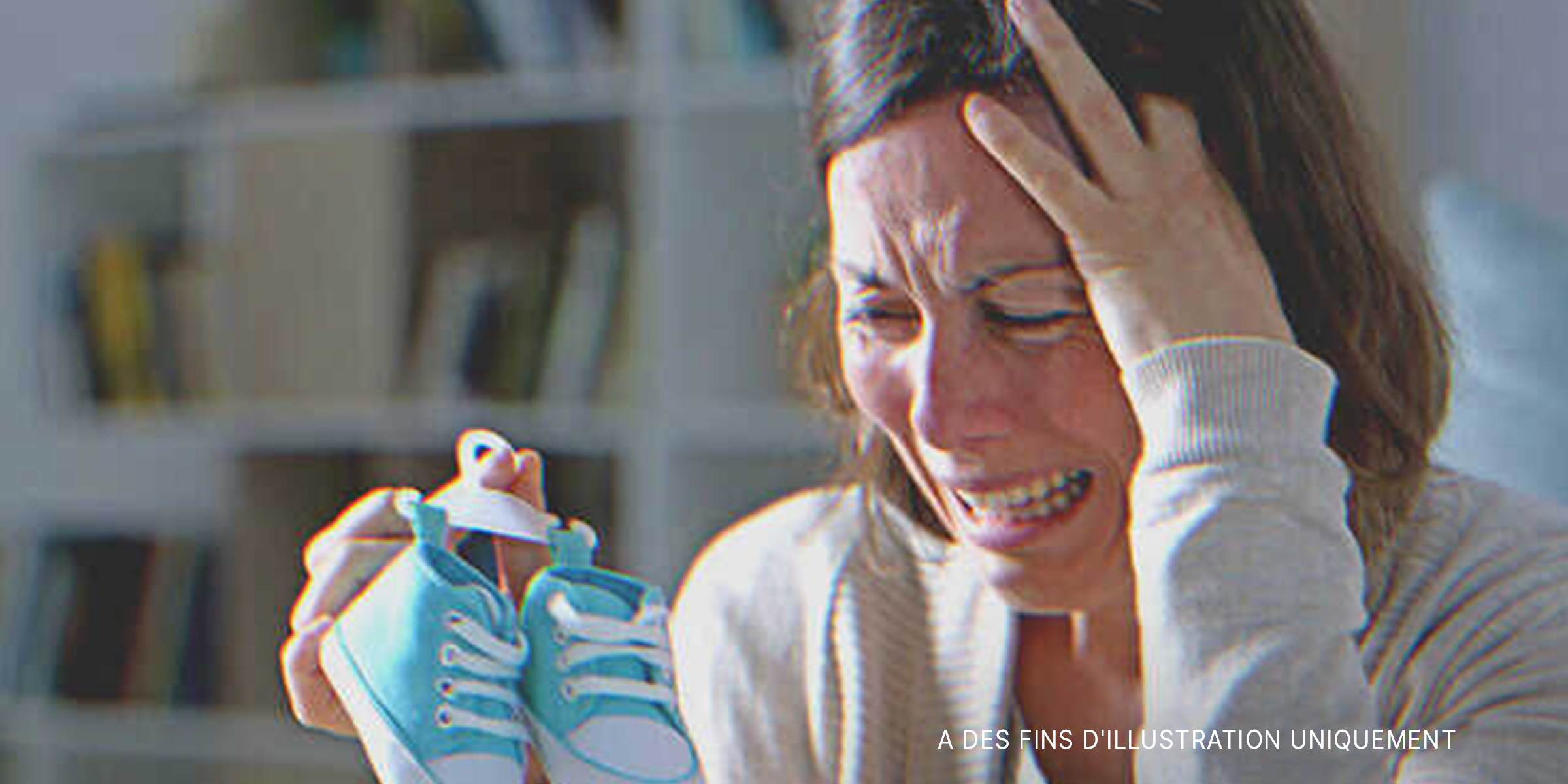 Une mère éplorée tenant une paire de chaussures bleues | Source : Shutterstock