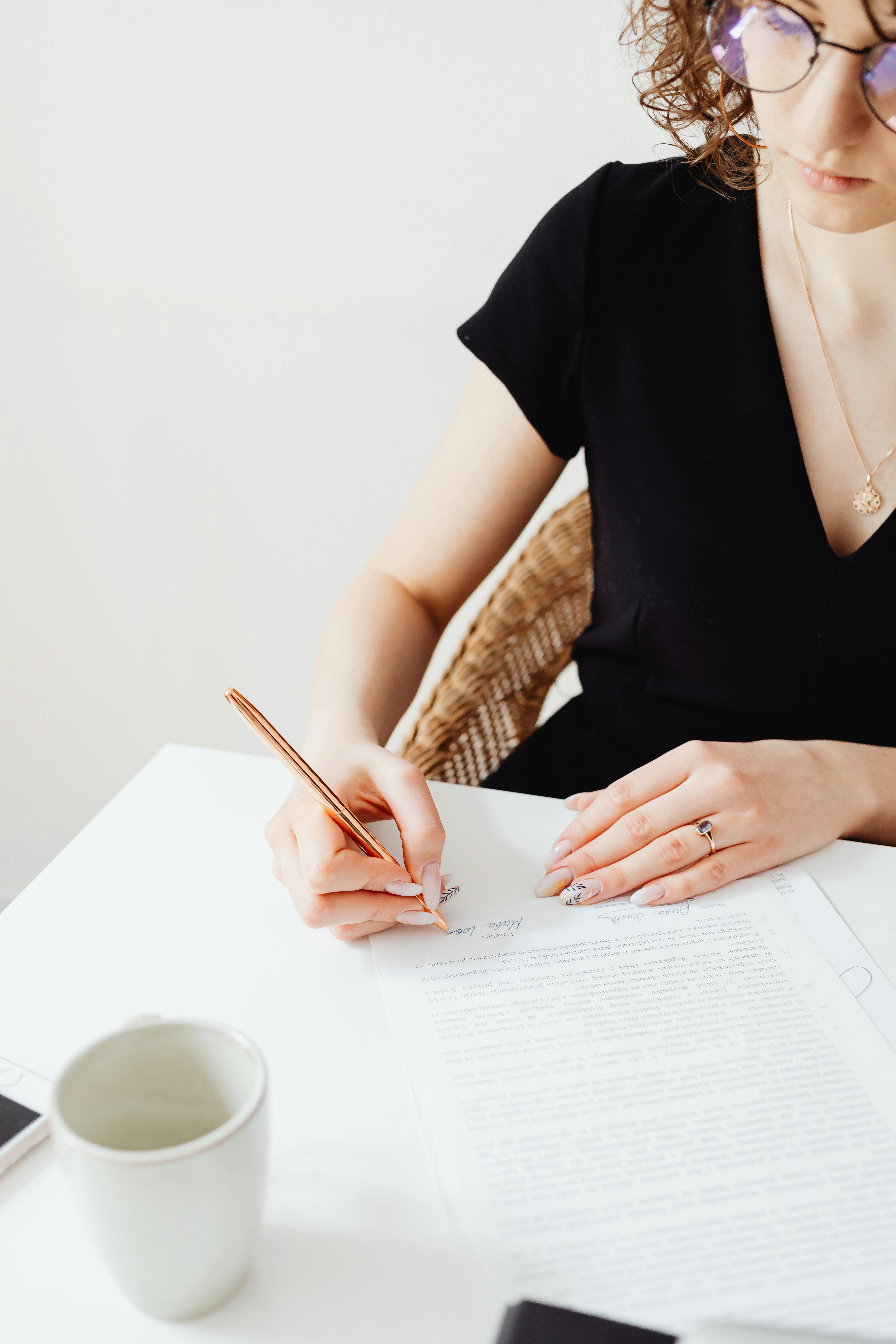 A woman signing a document | Source: Pexels