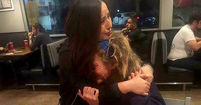 A homeless woman crying in the arms of Carmen Mendez.┃Source: facebook.com/carmen.mendez.39142 