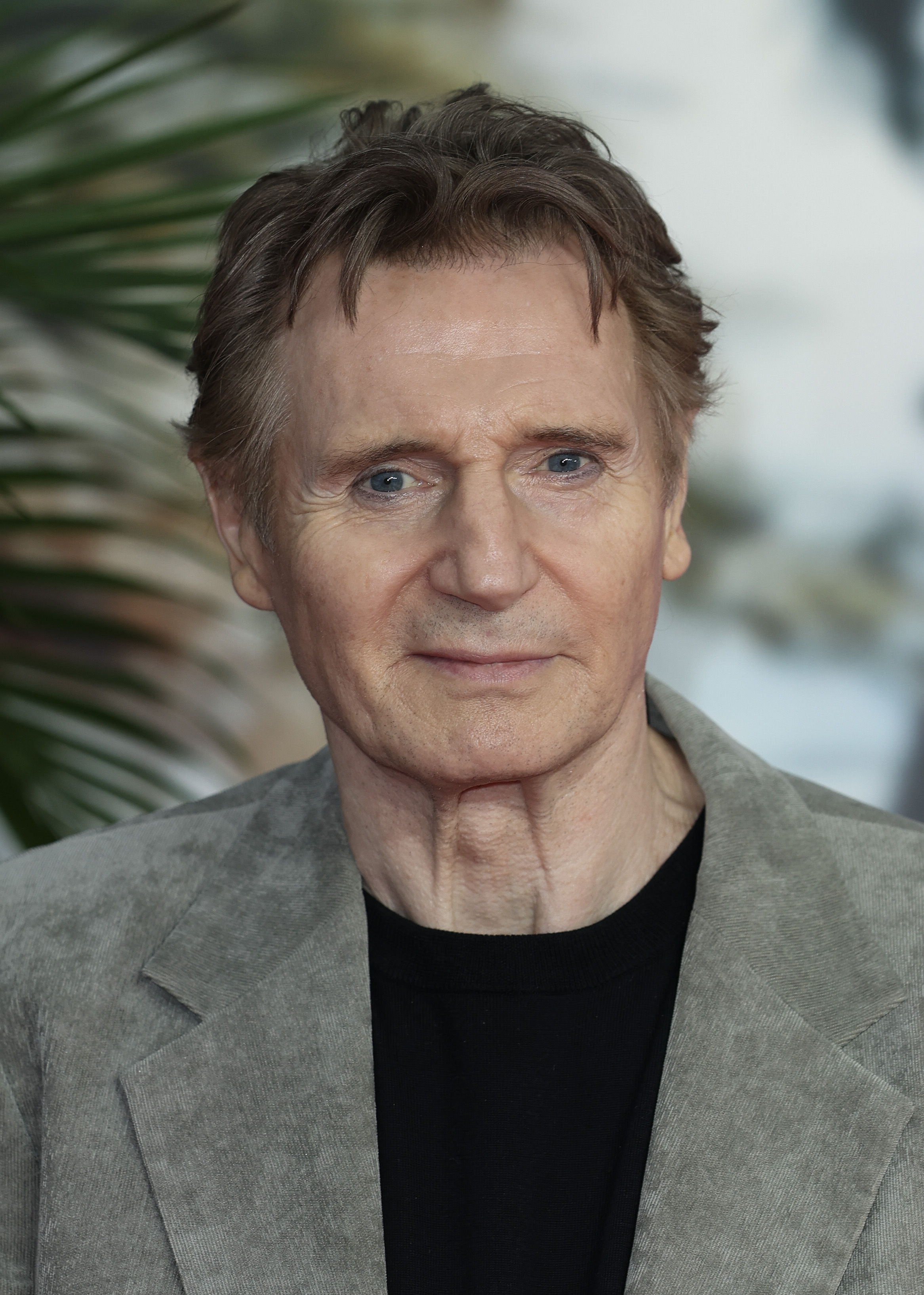 Liam Neeson smirks at the camera on the red carpet of the "The Naked Gun" UK Premiere at Cineworld Leicester Square in London, England on July 22, 2025 | Source: Getty Images
