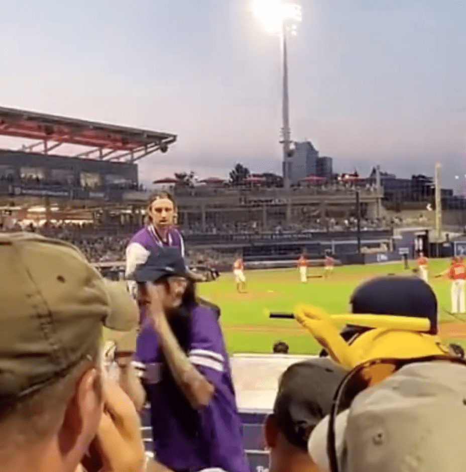 A woman lifts up her hands in disbelief because her partner has just proposed in front of a packed stadium | Photo: Instagram/wtwmass 