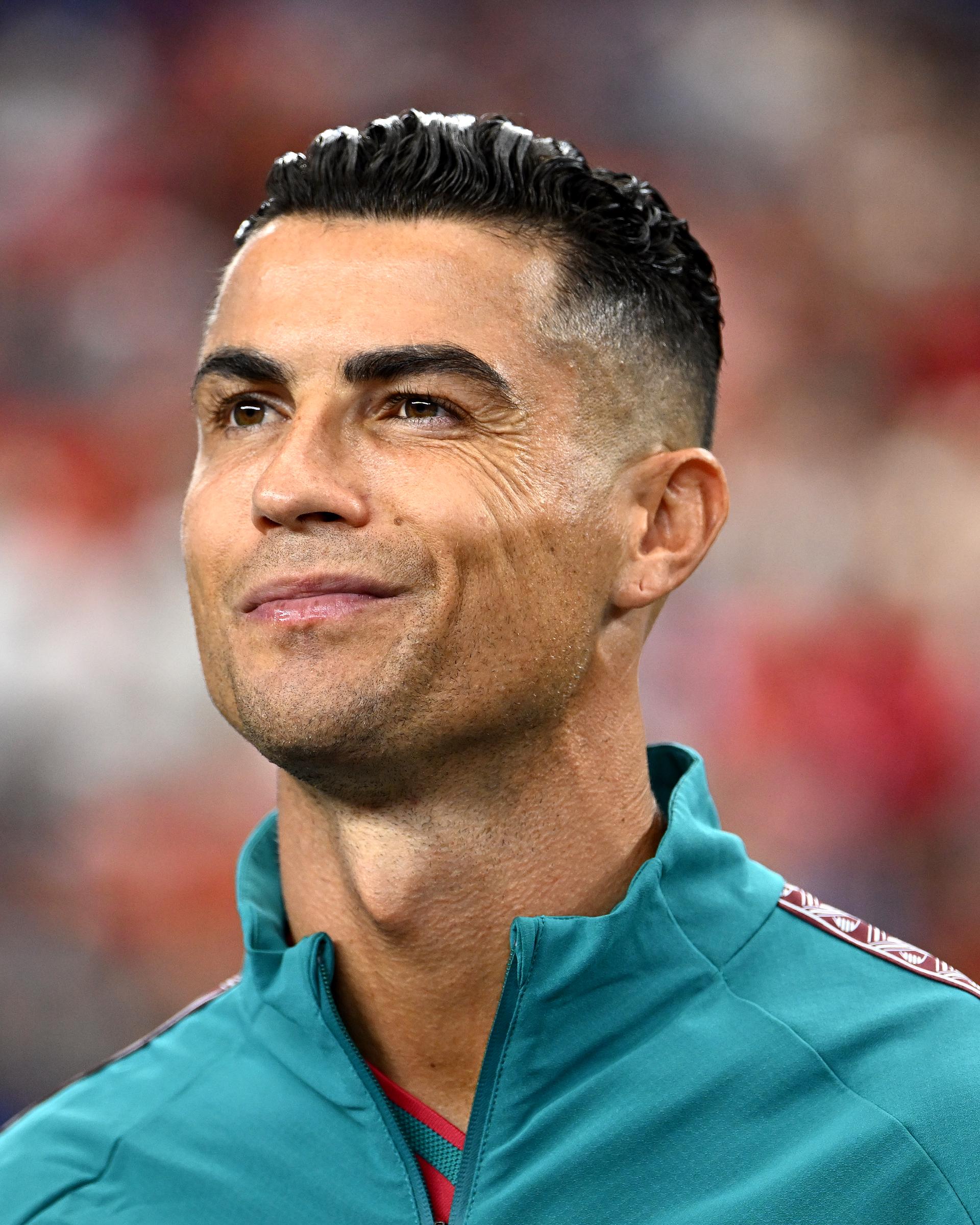 Another close-up from the same pre-match appearance offered a different angle as Ronaldo smiled before taking the field. The image emphasized the subtle lines around his eyes that became visible when he smiled while also showcasing the defined jawline, immaculate hairstyle, and bright smile that have become hallmarks of his appearance throughout the latter stages of his career.