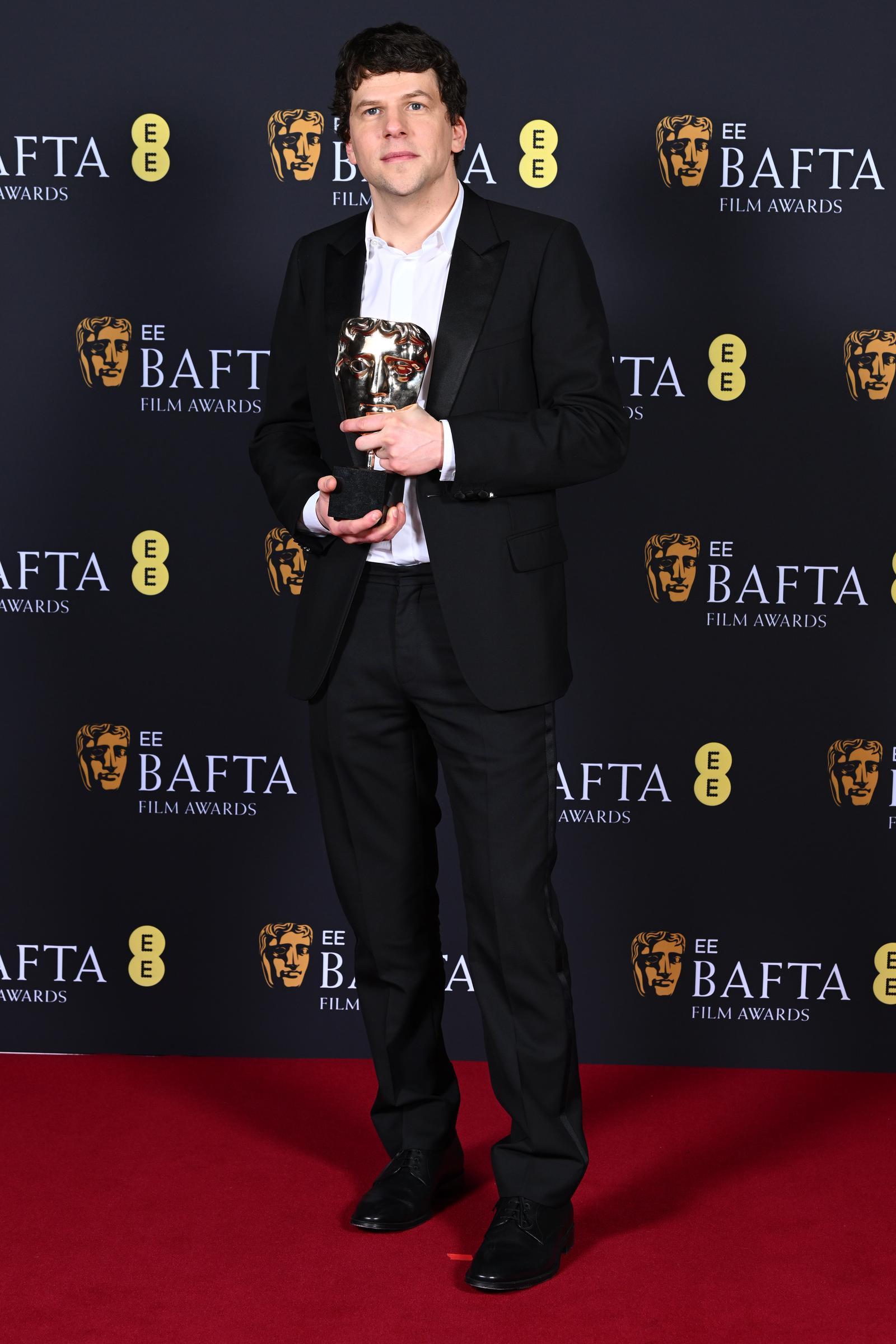 Jesse Eisenberg poses with Kieran Culkin's Supporting Actor Award on February 16, 2025 | Source: Getty Images