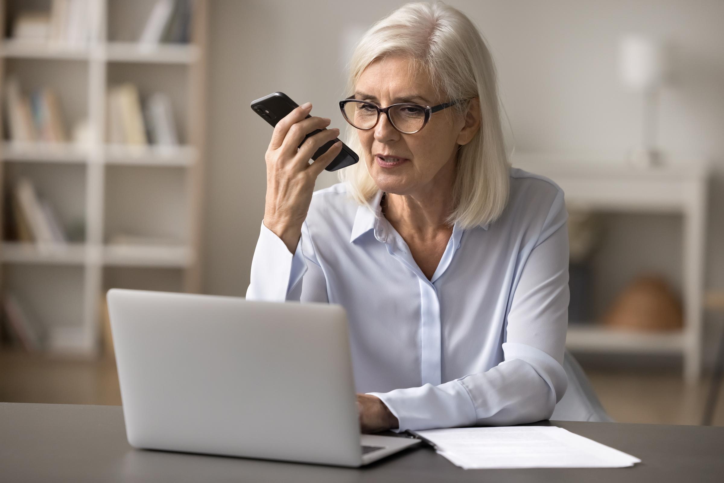 A woman taking a call while working on her computer | Source: Shutterstock